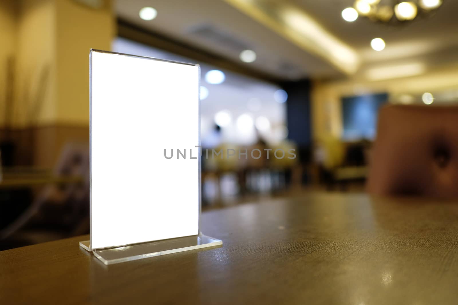 Mock up Menu frame standing on wood table in Bar restaurant cafe. space for text