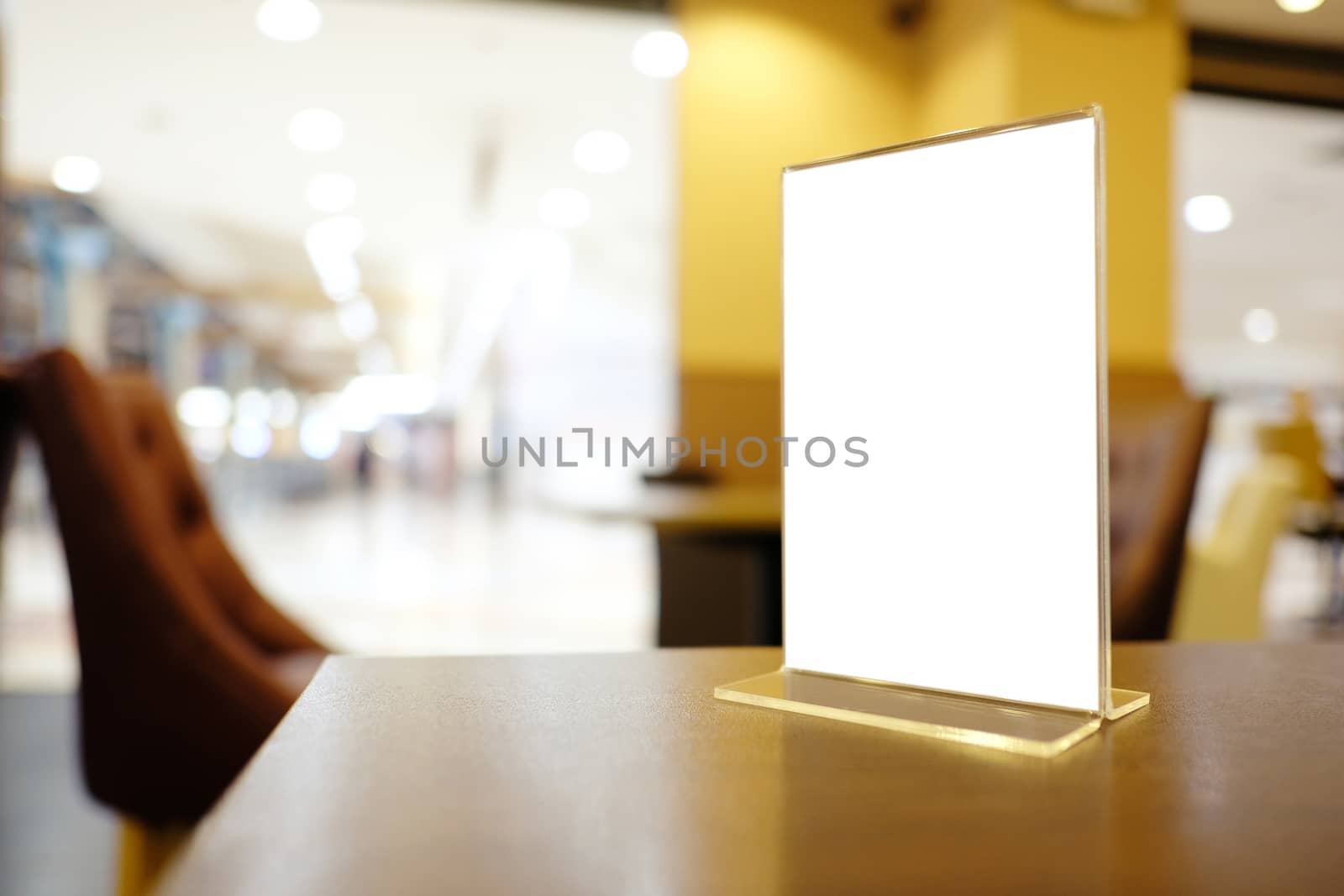 Mock up Menu frame standing on wood table in Bar restaurant cafe. space for text