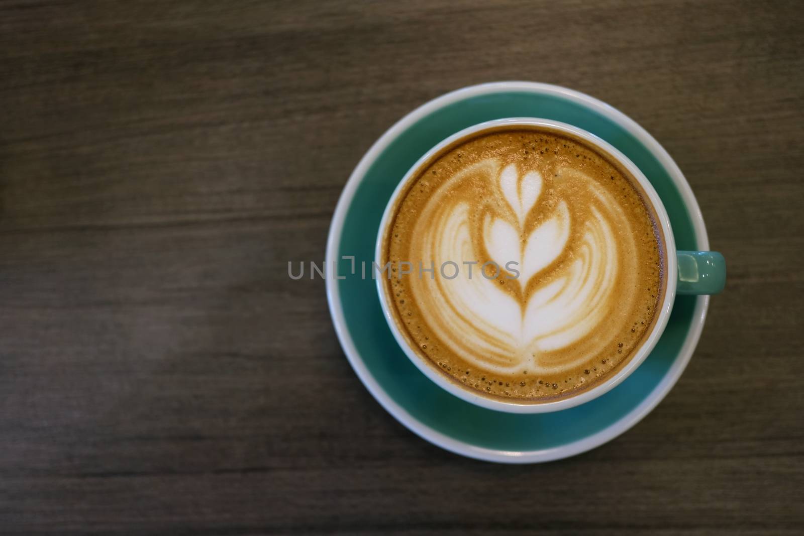 Cup of hot latte art coffee on wooden table