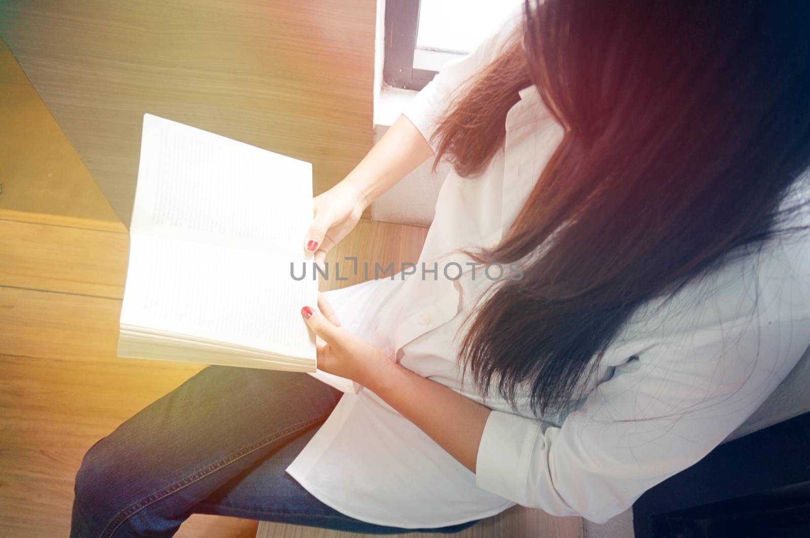 women reading book and relaxing in her living room by peandben