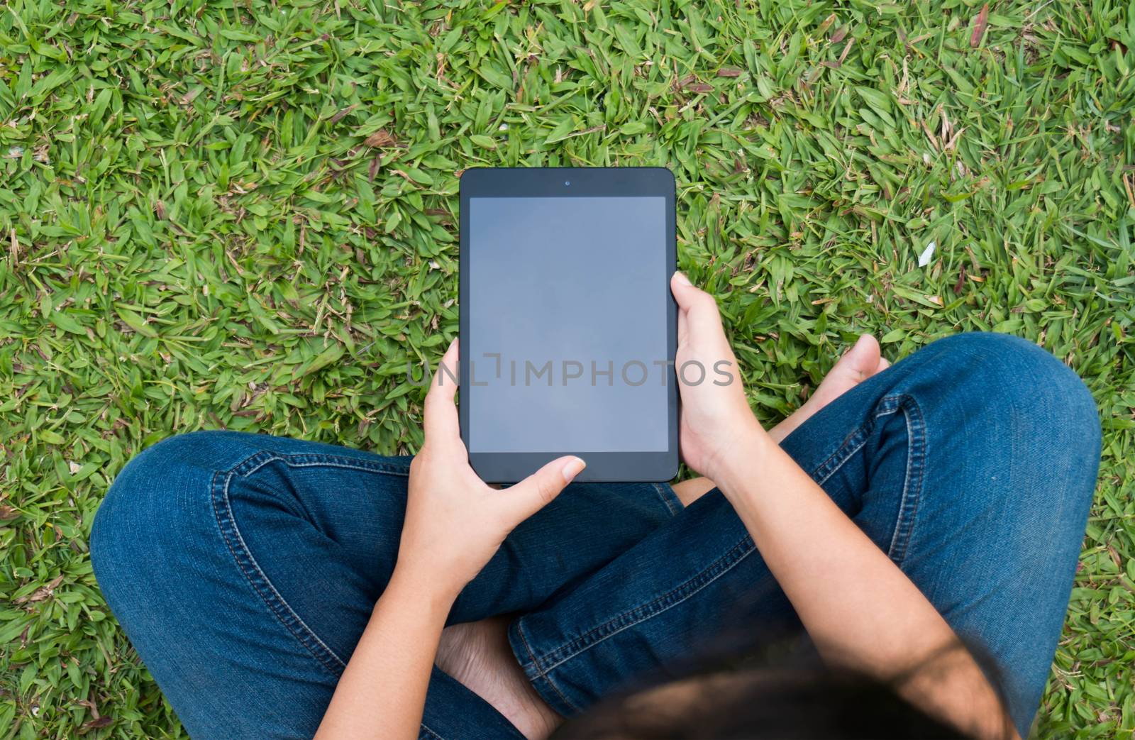 Top view girl sitting on the floor and working with tablet  Copy space for text