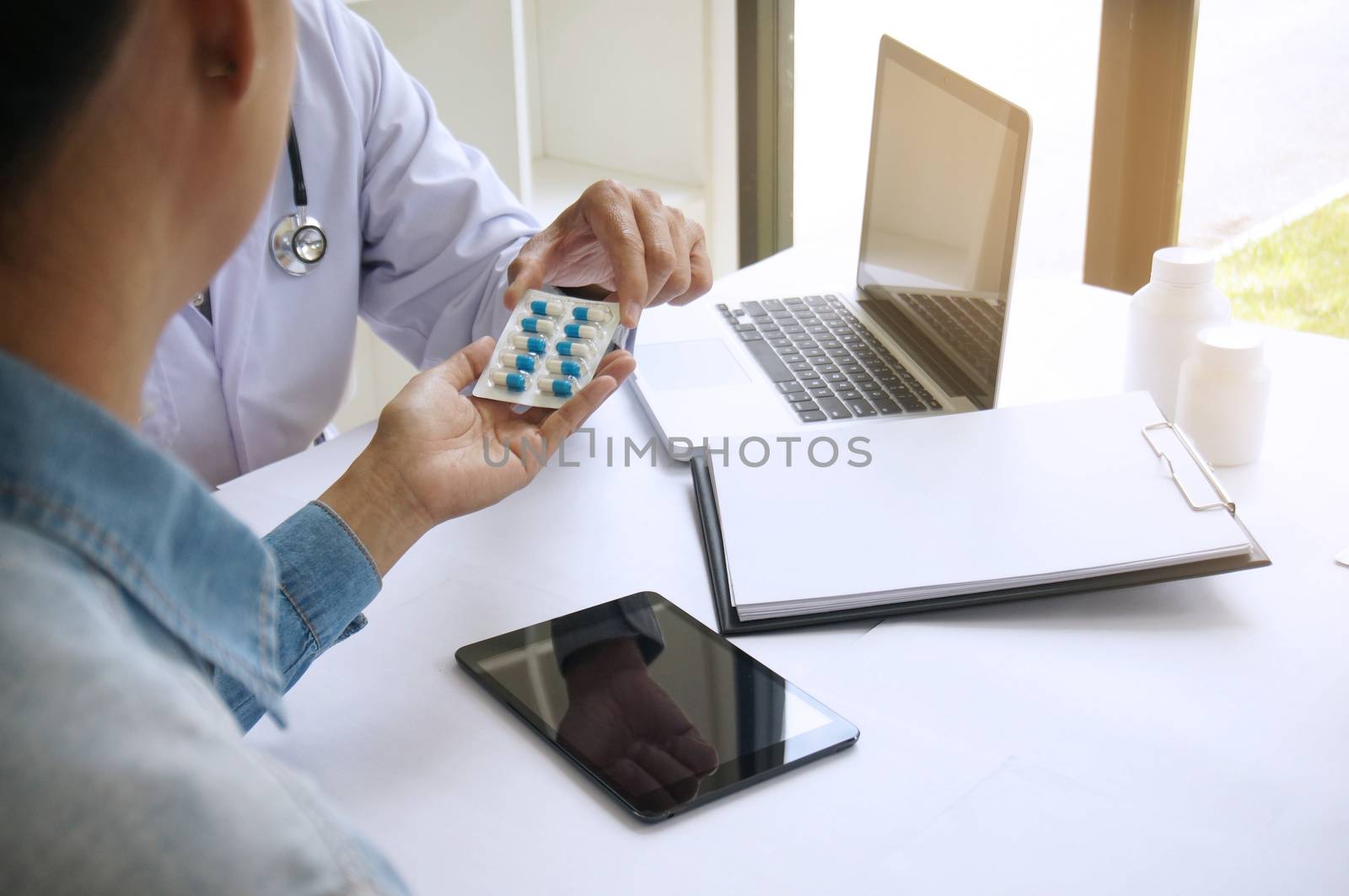 Doctor hand holding pack of different tablet blisters for patient. prescribe medicament.  disease healing concept.