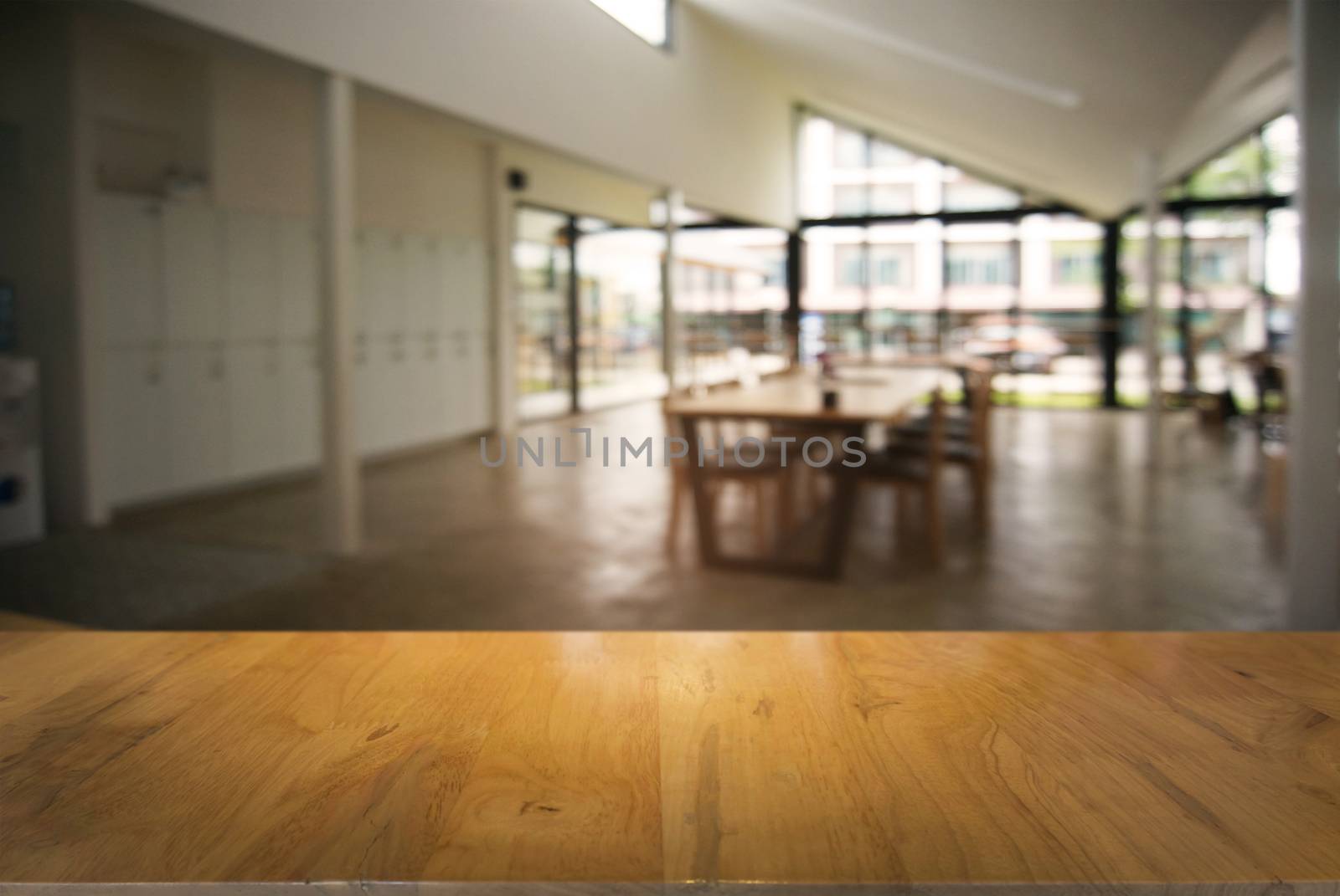 Empty wooden table in front of abstract blurred background of co by peandben