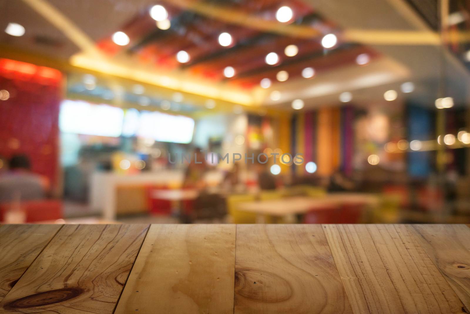 Empty wooden table in front of abstract blurred background of co by peandben