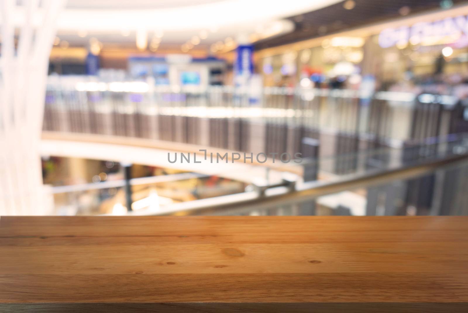 Empty wooden table in front of abstract blurred background of co by peandben