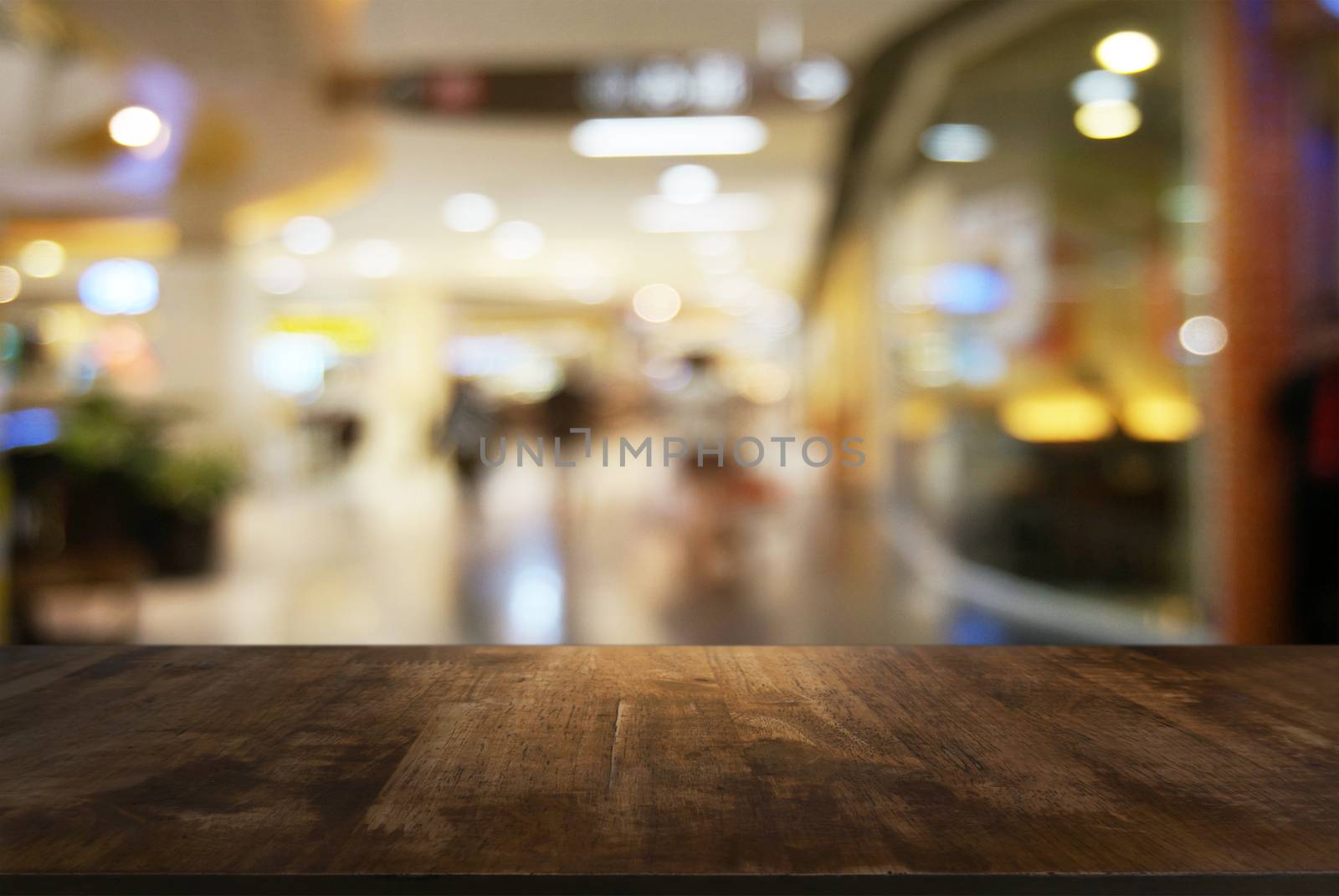 Empty wooden table in front of abstract blurred background of co by peandben