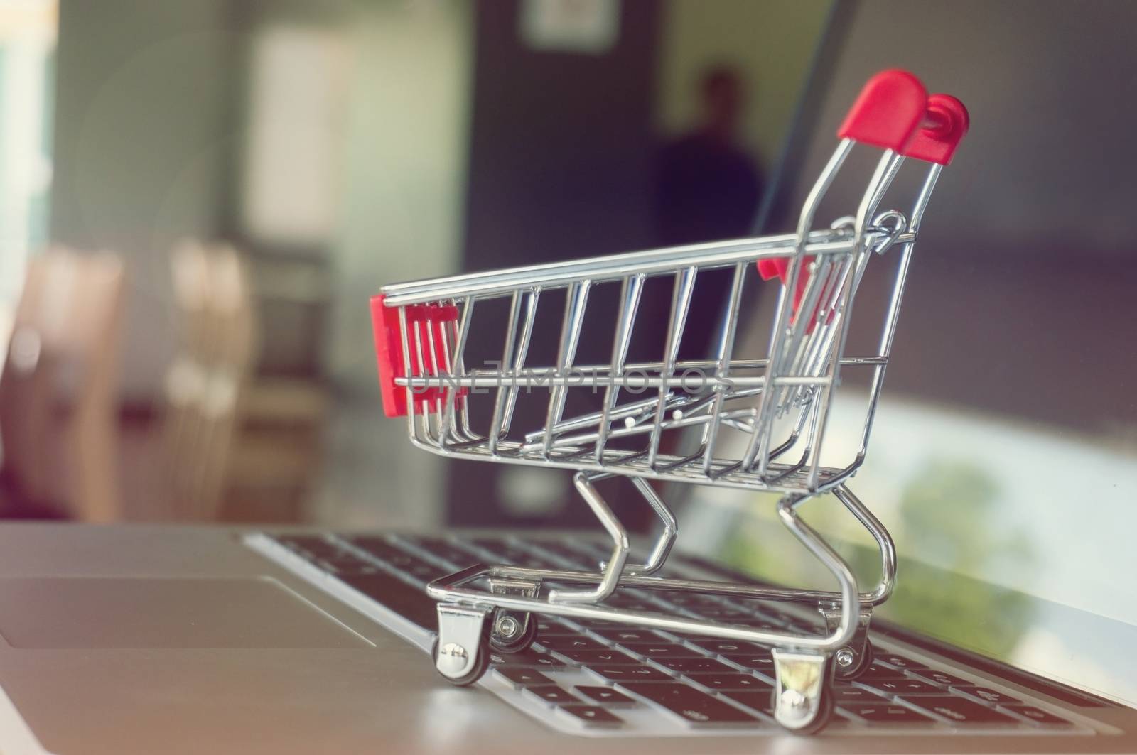 Small shopping cart with Laptop for shopping online concept.