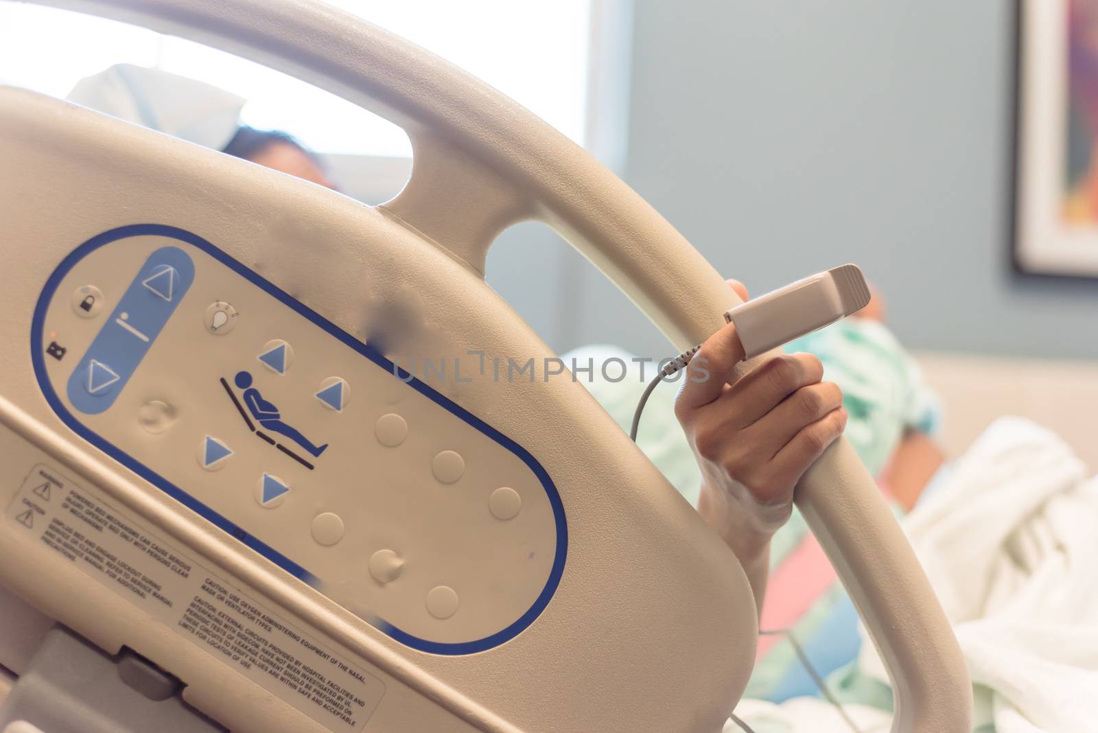 Asian woman patient wear fingertip pulse oximeter holding birthing bed bar at labor and delivery room in American hospital