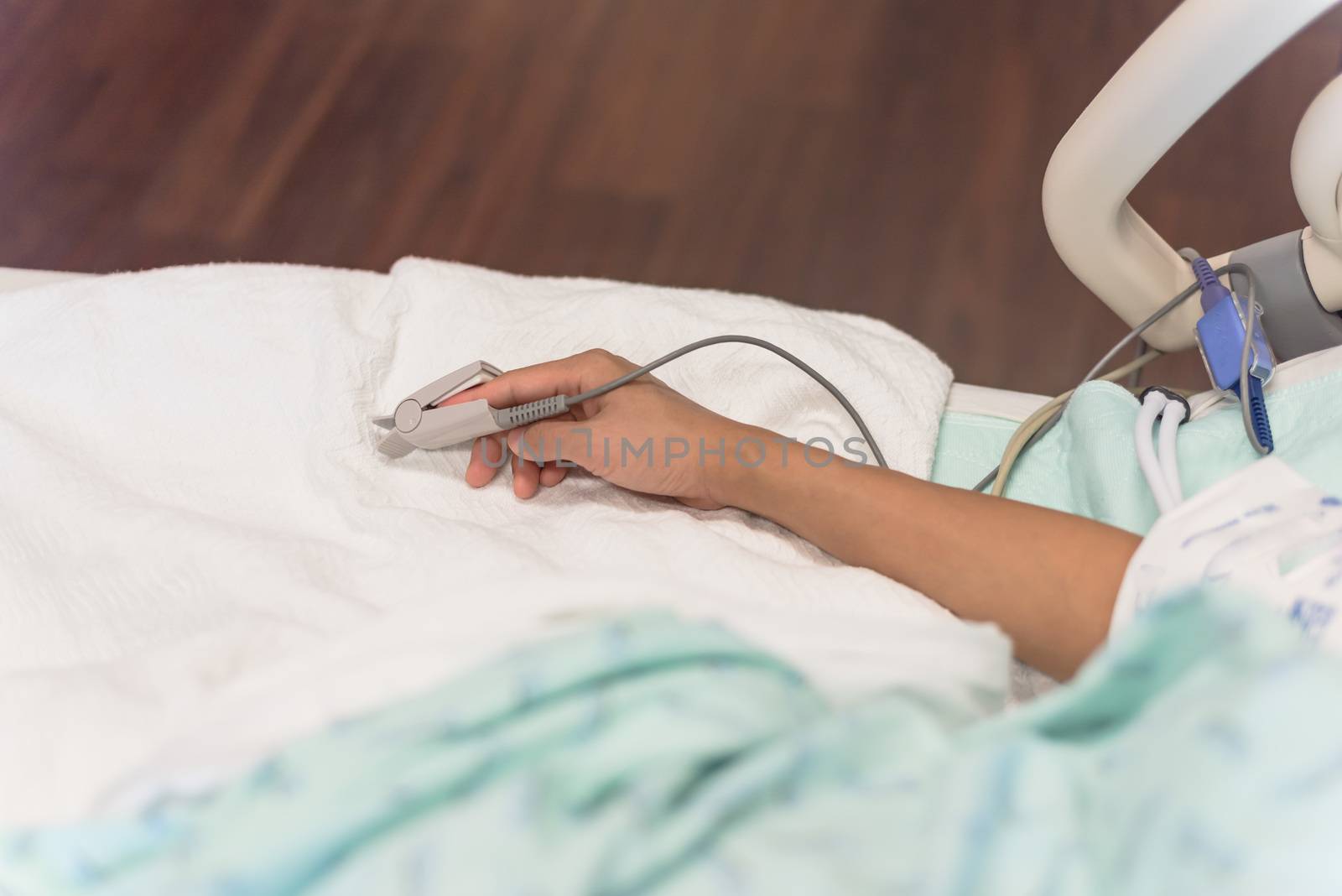 Close-up pulse oximeter in a lady patient fingertip for heart rate and blood oxygen level monitoring at labor and delivery room