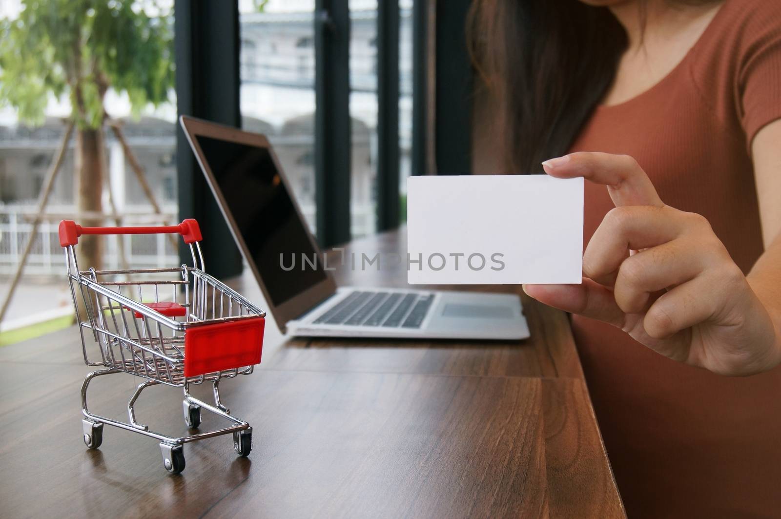 Small shopping cart with Laptop and business card copy space screen for shopping online concept