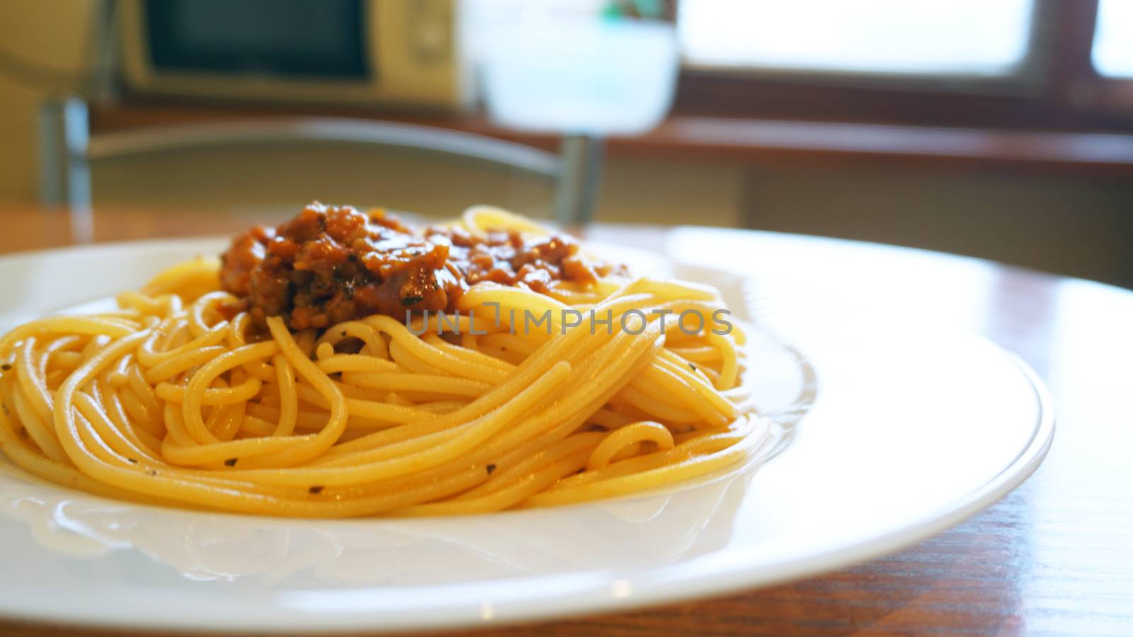 Plate of delicious spaghetti Bolognaise or Bolognese with savory minced beef and tomato sauce garnished, overhead view