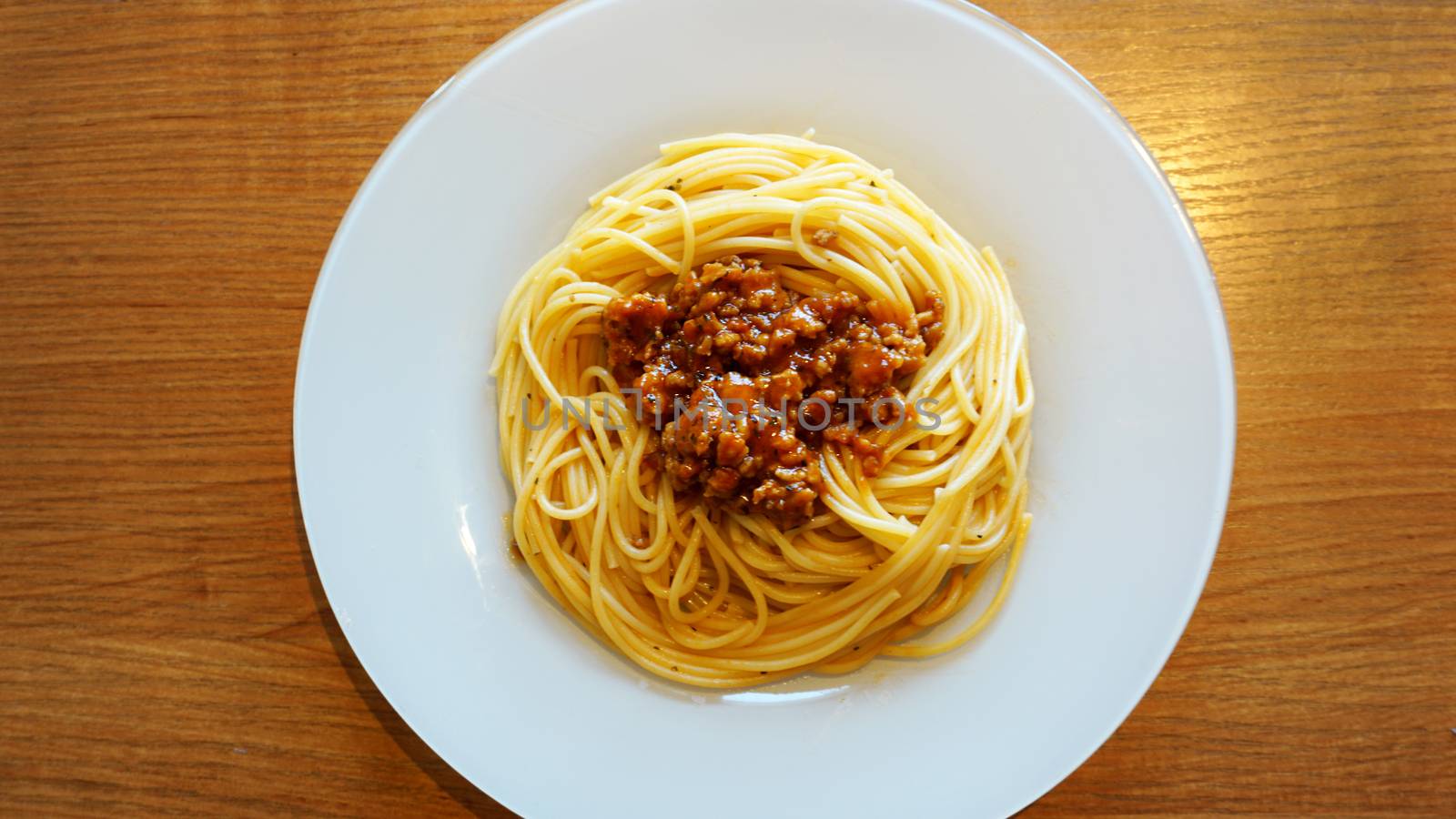 Plate of delicious spaghetti Bolognaise or Bolognese with savory minced beef and tomato sauce garnished, overhead view