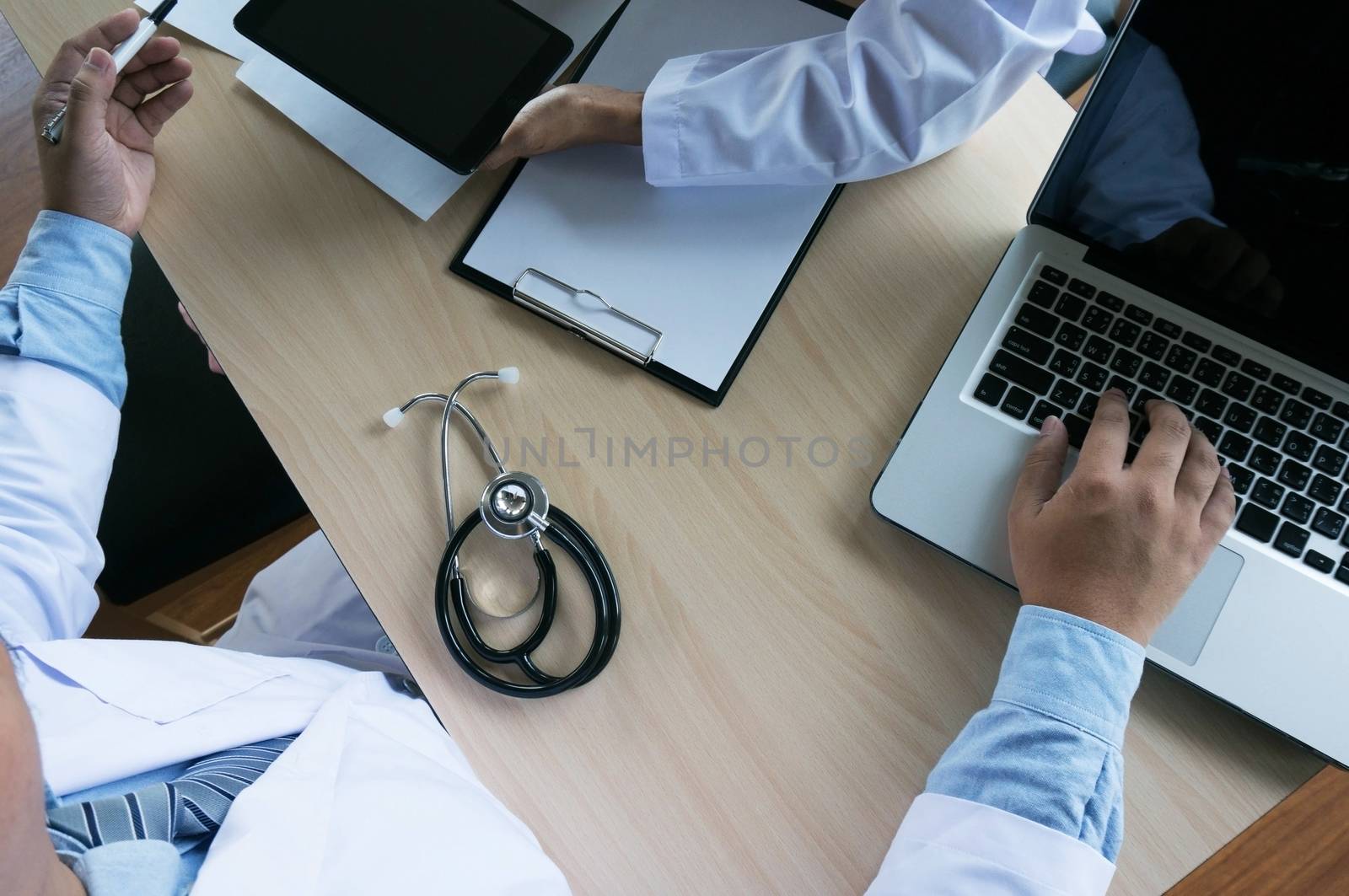 Professional medical doctor in white uniform gown coat working laptop computer