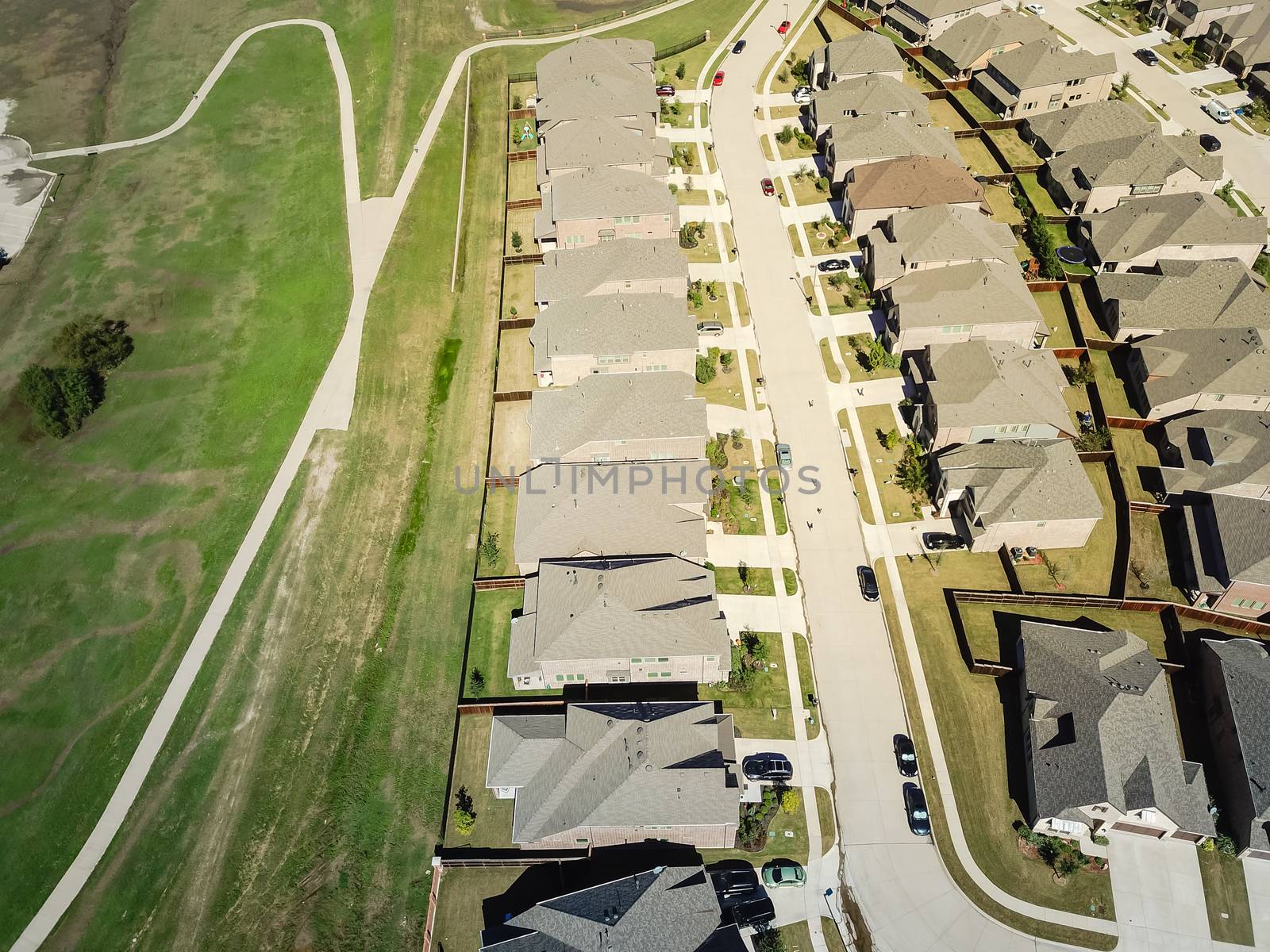 Top view new established neighborhood with brand new houses near park and pathway trail. Flyover residential area in suburban Dallas, Texas, USA