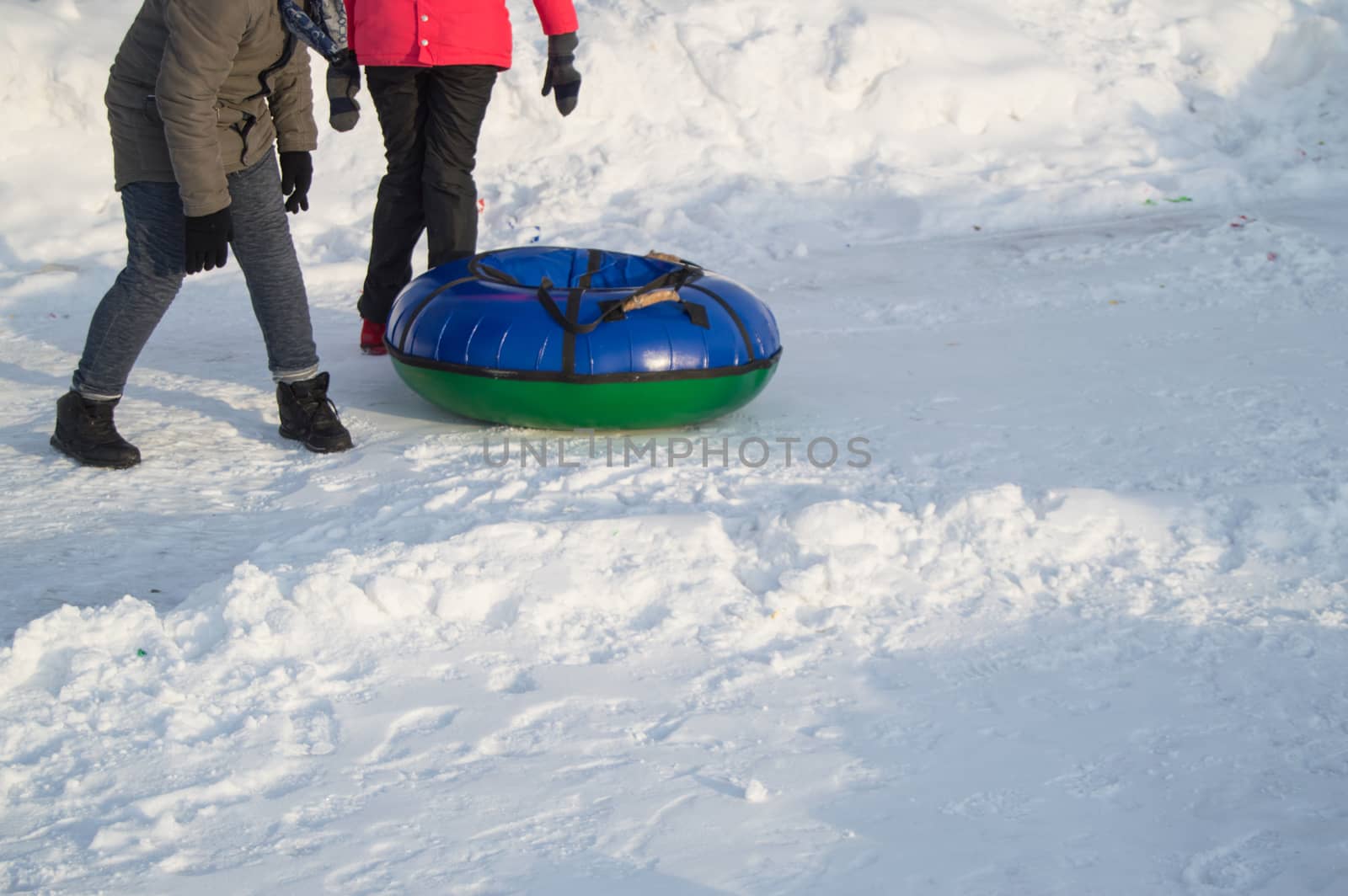 Two teenage girls rolled down the mountain on a tubing, winter fun in the Park.