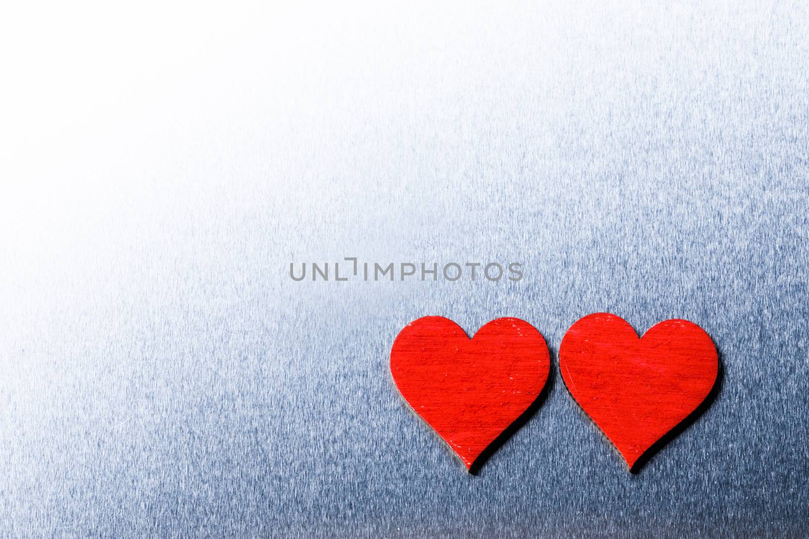 Two wooden red painted Valentine day hearts on metal background with copy space for text