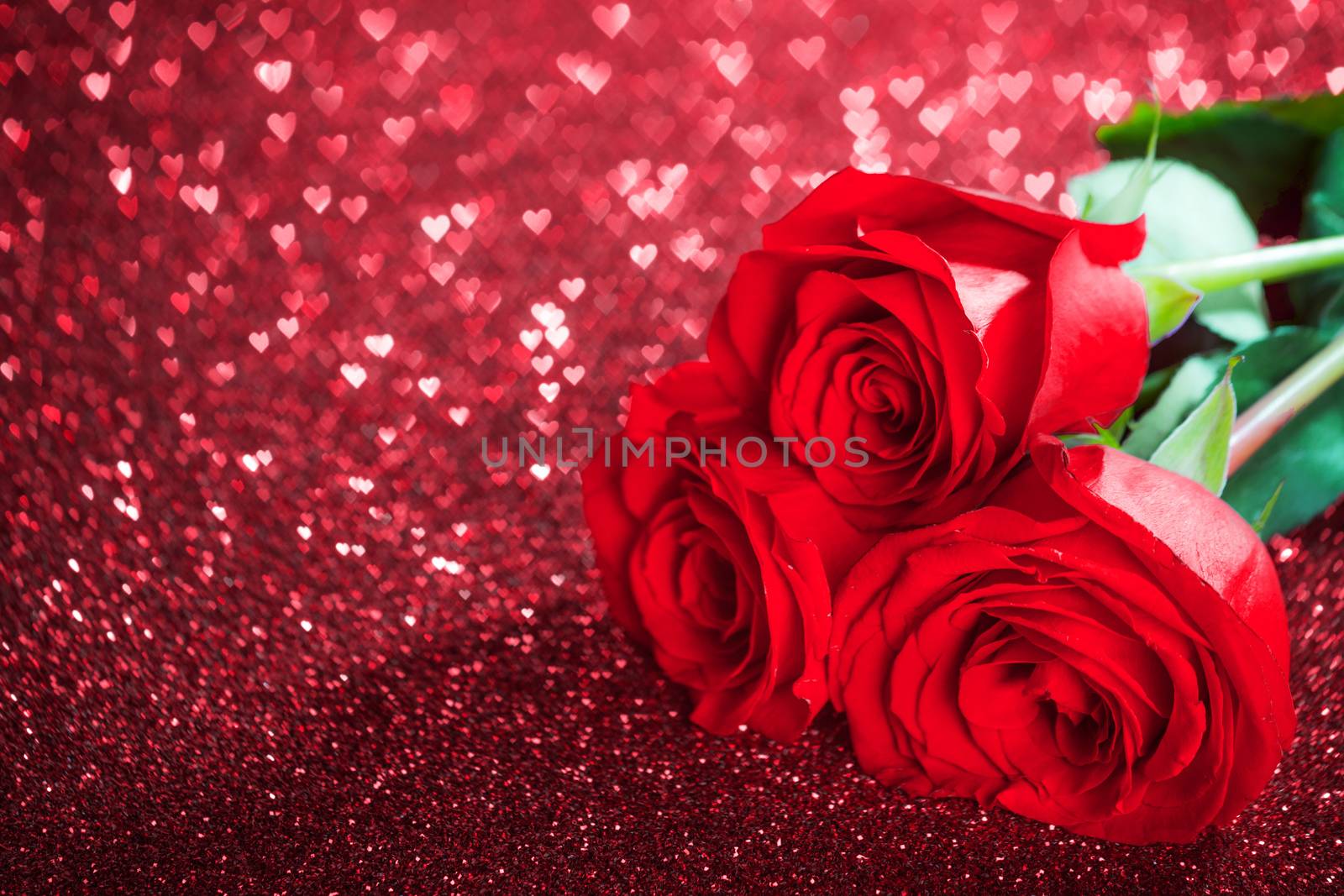 Red rose flowers on glitter hearts bokeh background with copy space Valentine day concept