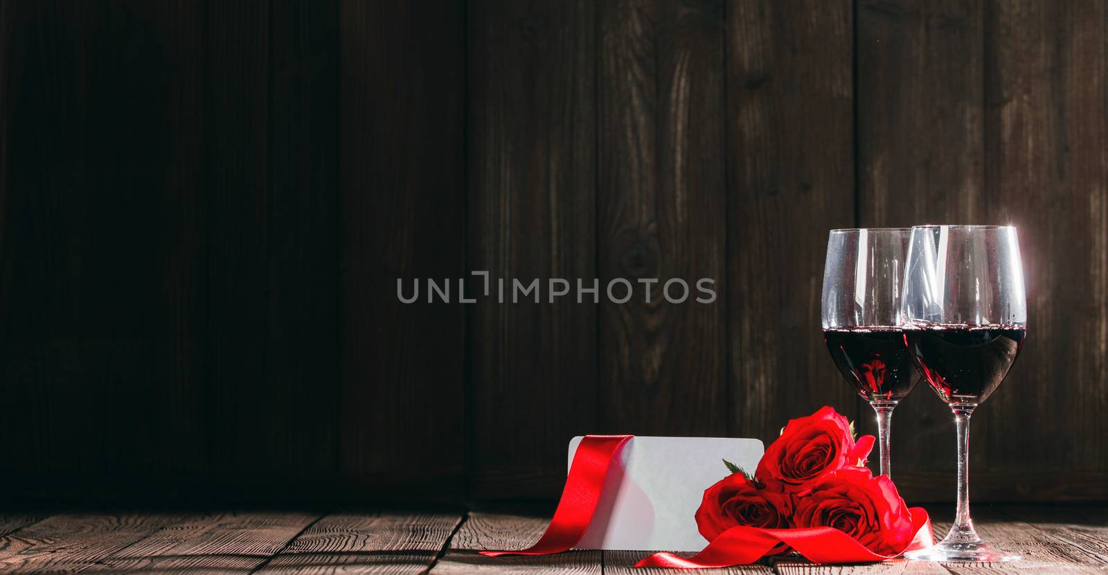 Two glasses of red wine , roses and greeting card for Valentine day
