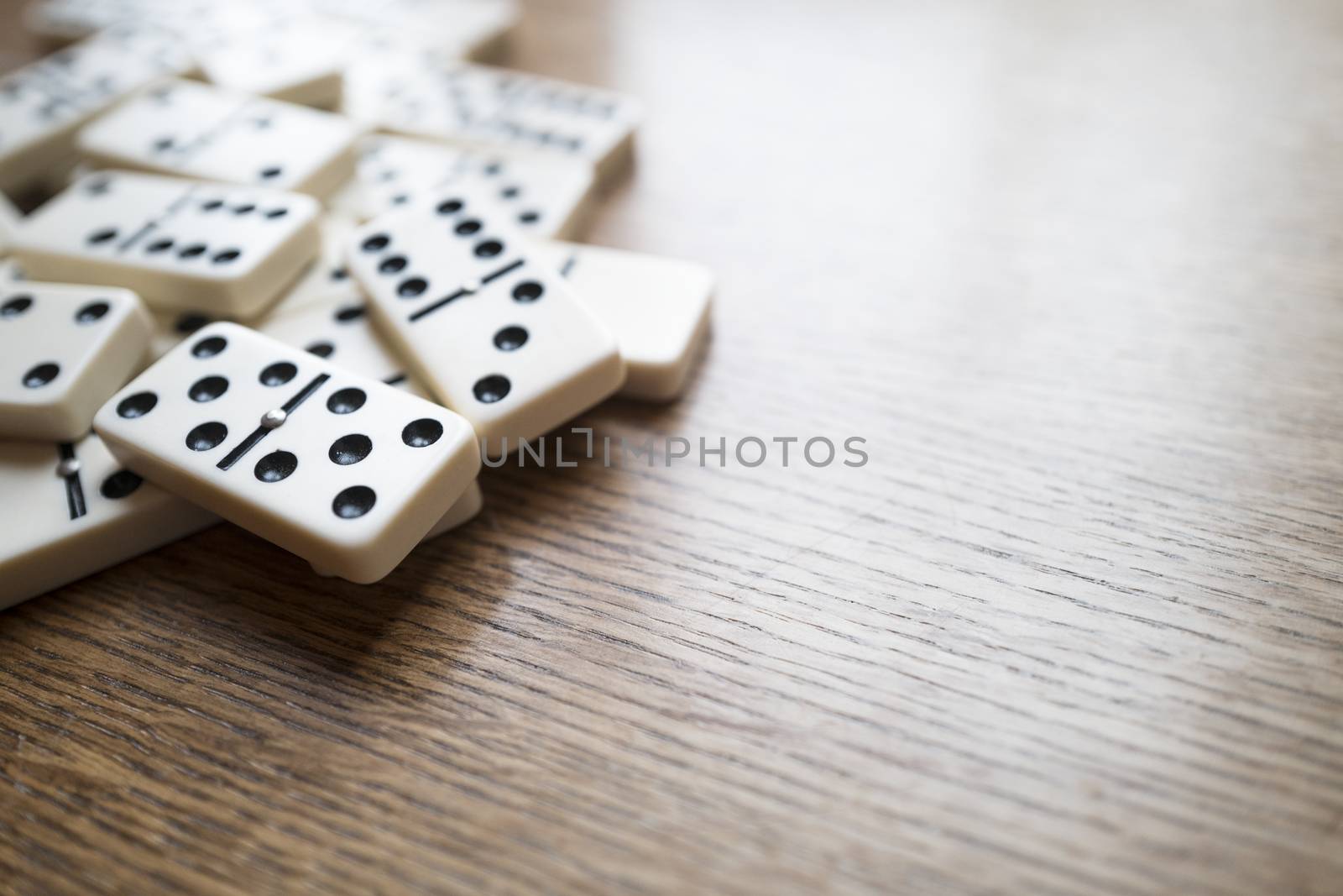 Horizontal image of dominoes on a wooden table, horizontal image with empty space on the right 