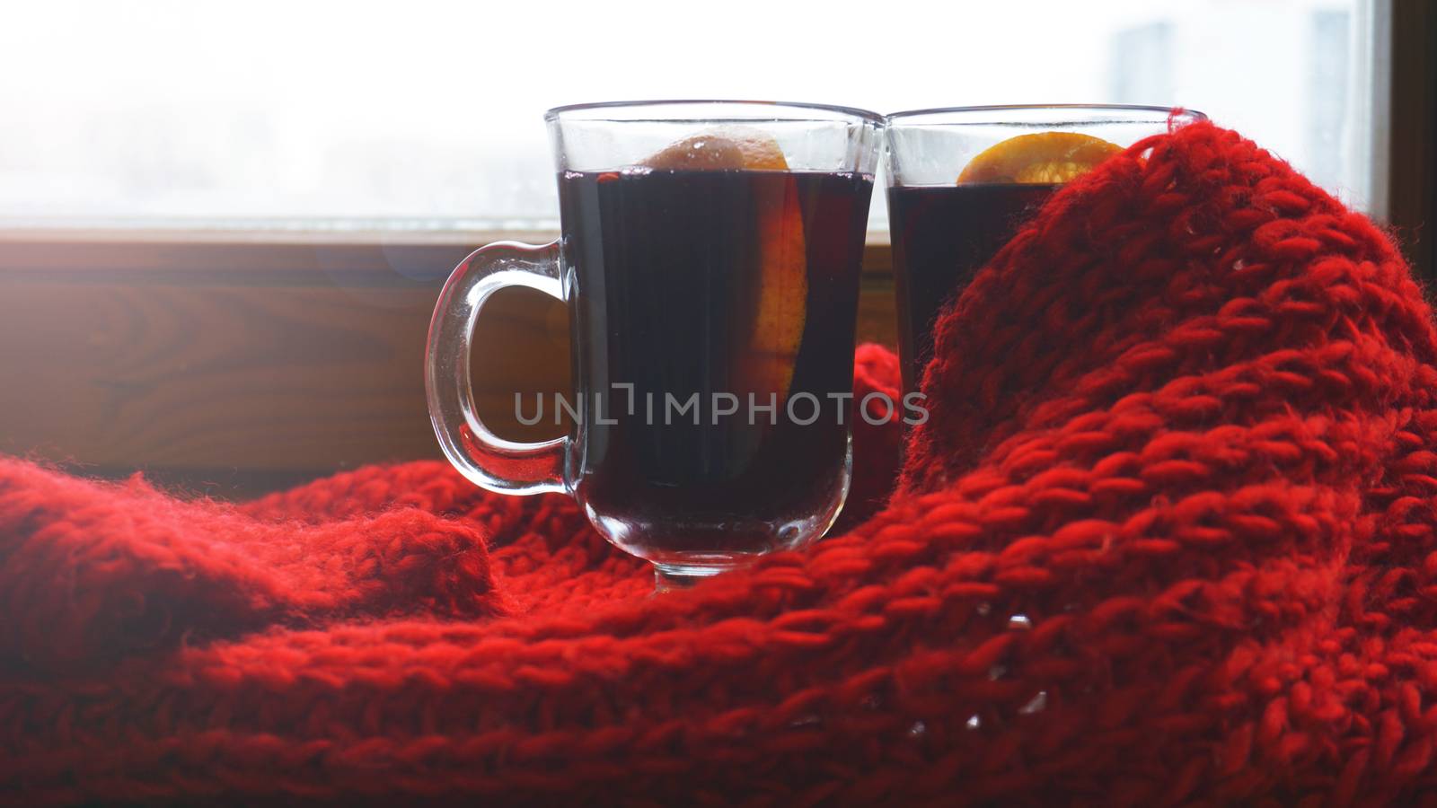 Hot Mulled Wine for winter and Christmas on wooden table with copy space. Red Hot wine with orange and red scarf