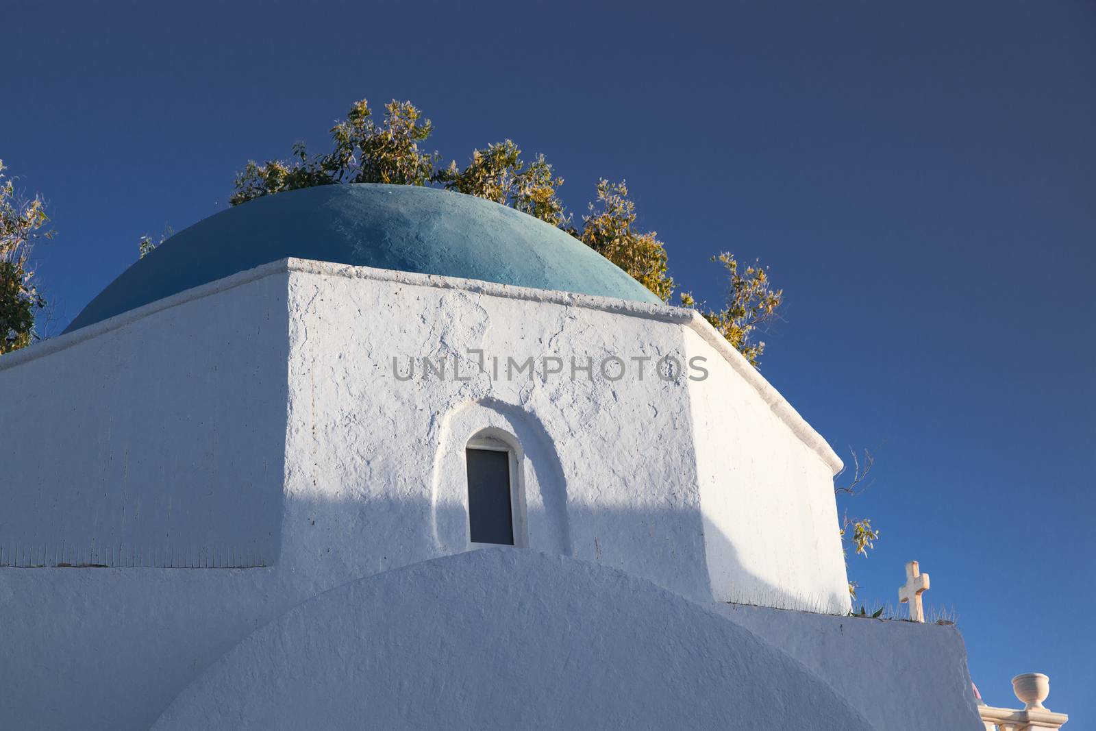 traditional narrow street in Mykonos with blue doors and white walls