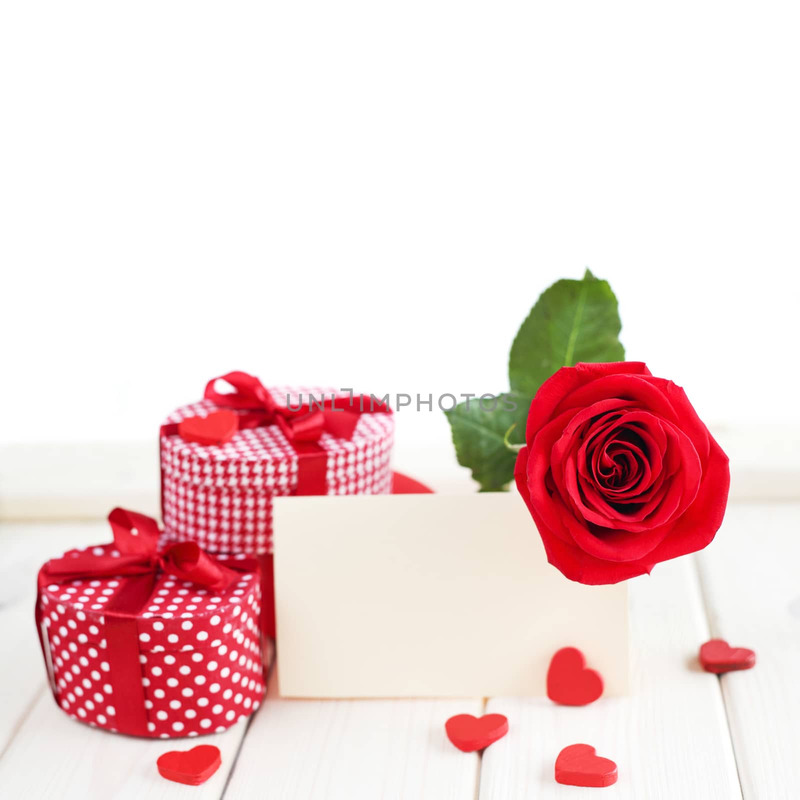Red rose, heart and blank card on wooden table, valentines day concept