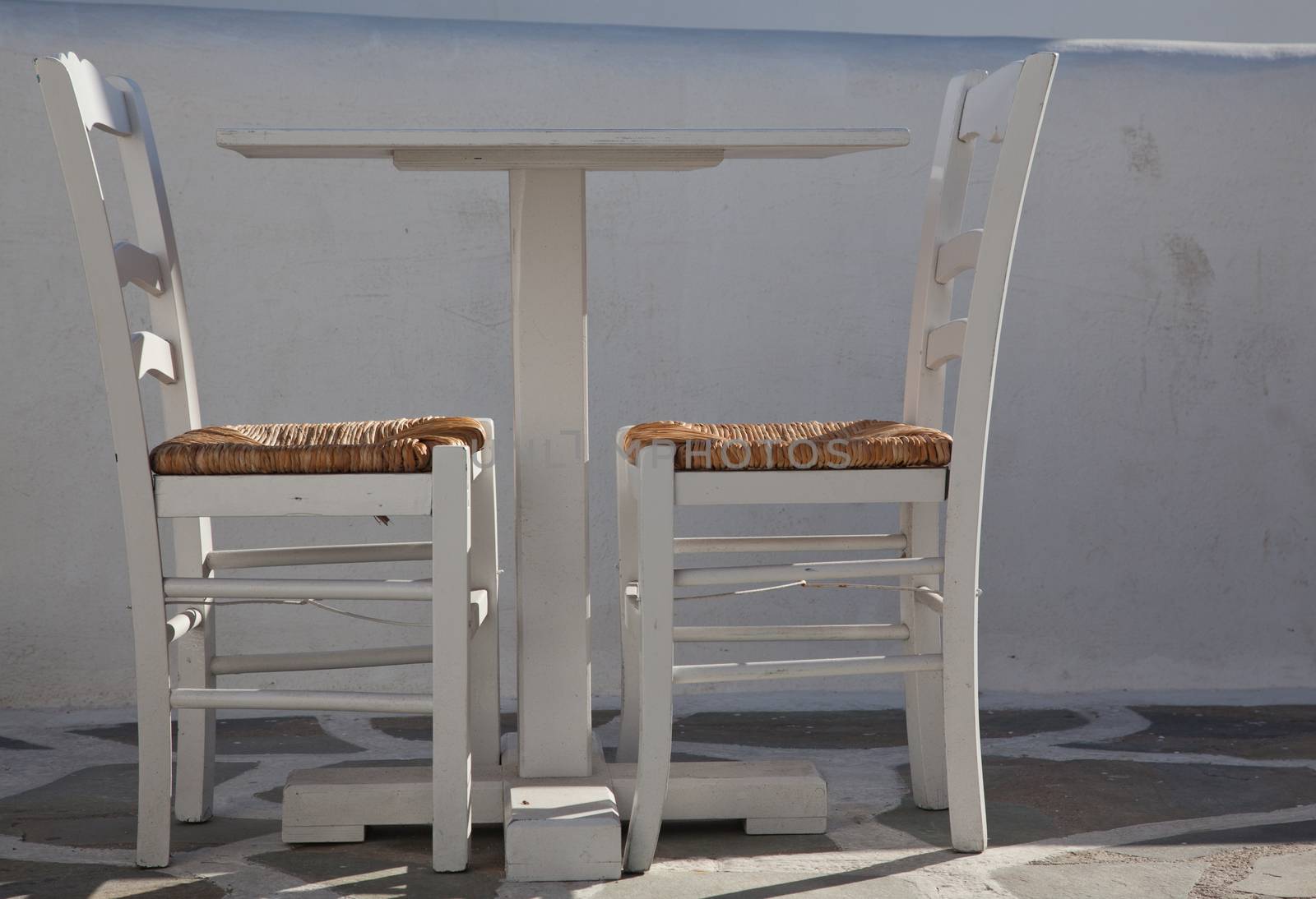 traditional narrow street in Mykonos with blue doors and white walls