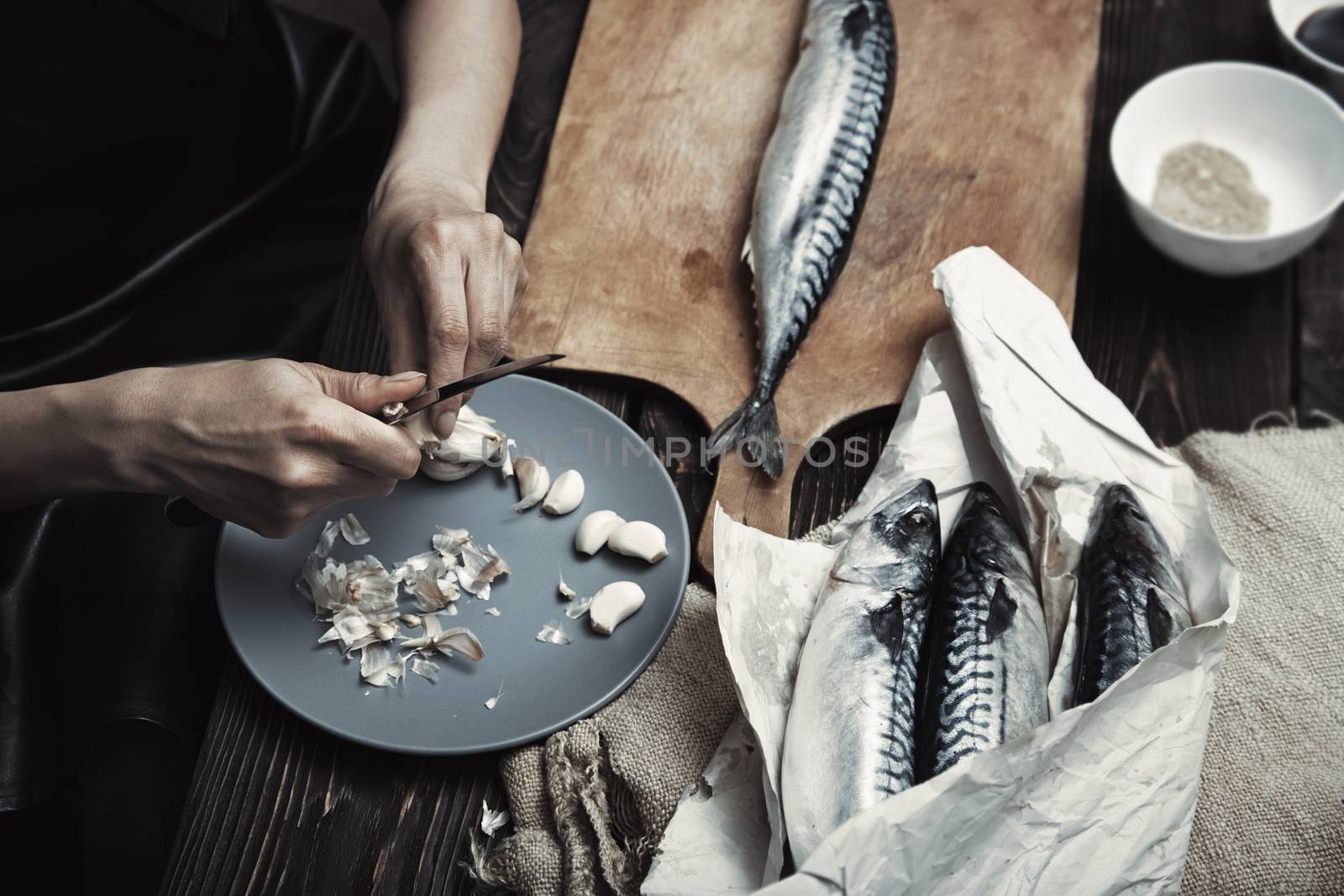 Woman preparing mackerel fish by Novic