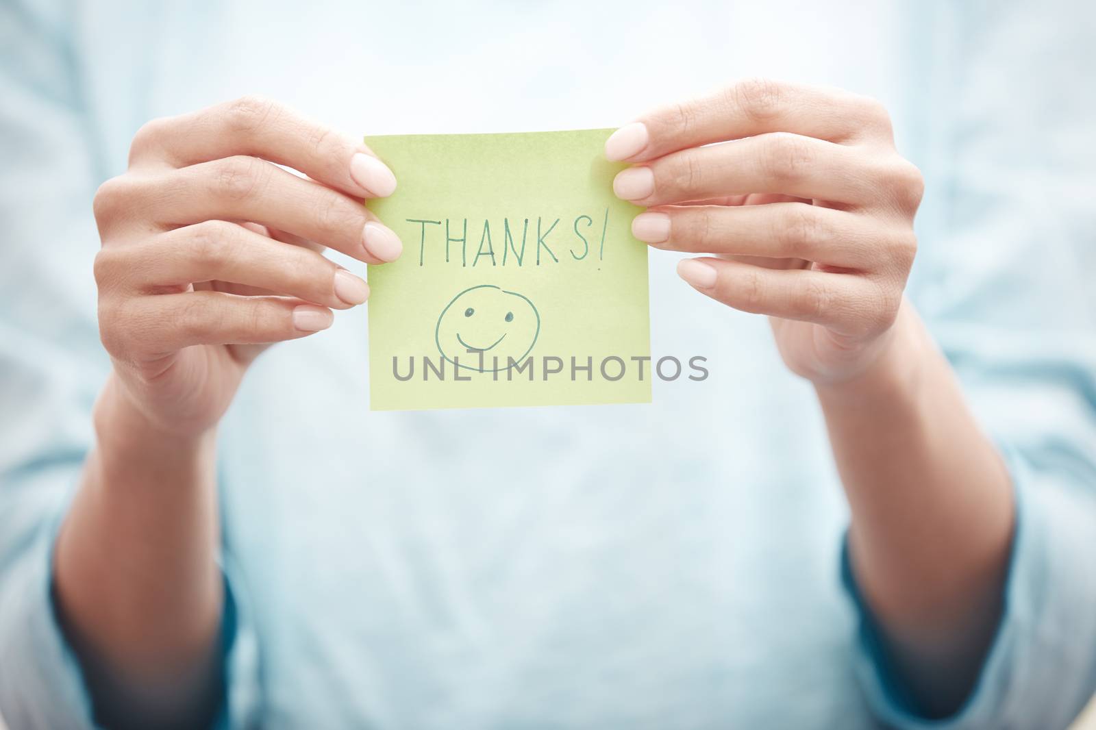 Yoga instructor holding sticky note with Thanks text