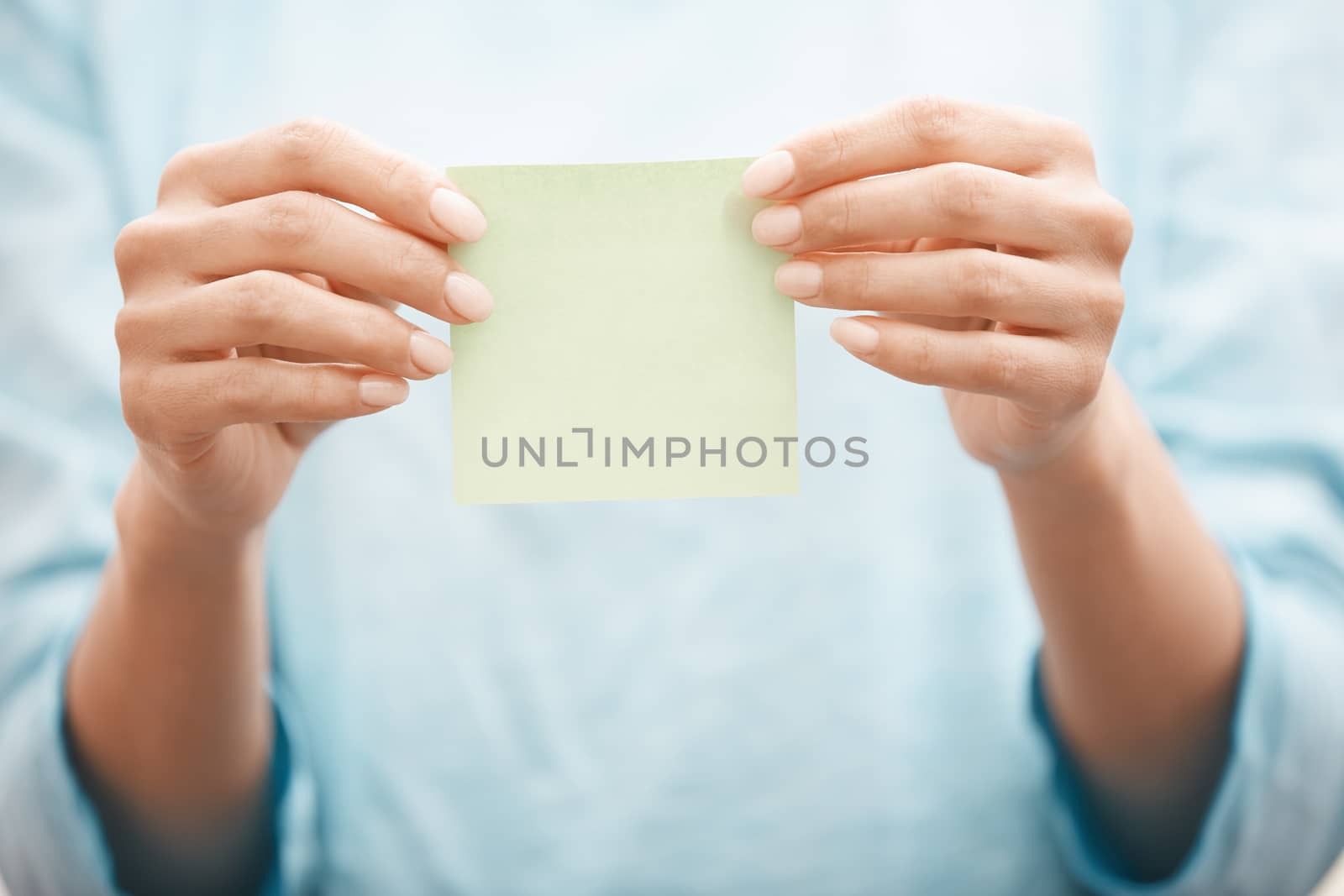 Woman holding adhesive note by Novic