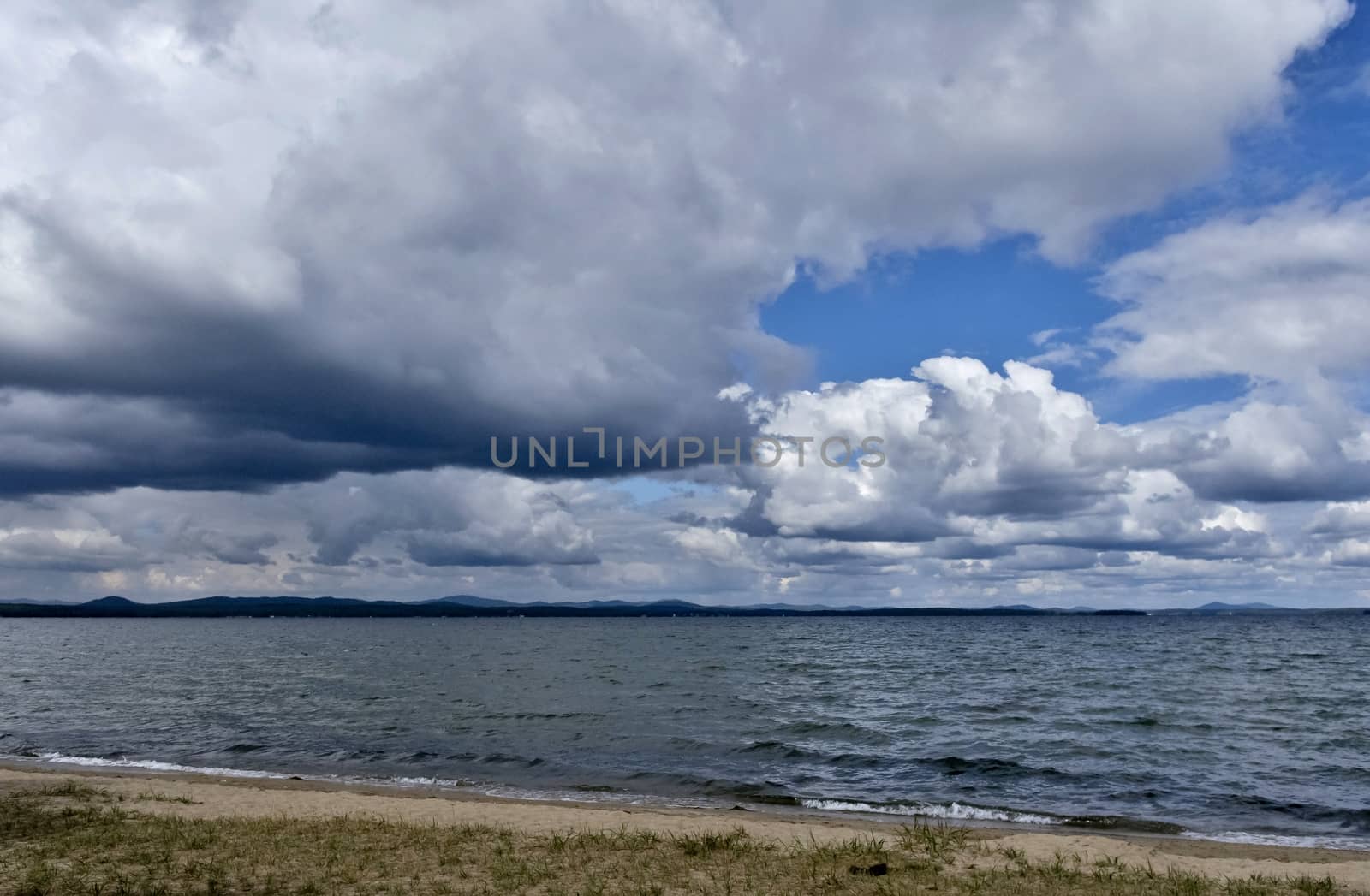 day lake in gray-white cloudy weather, South Ural, Uvildy, in the distance are seen the Ural mountains