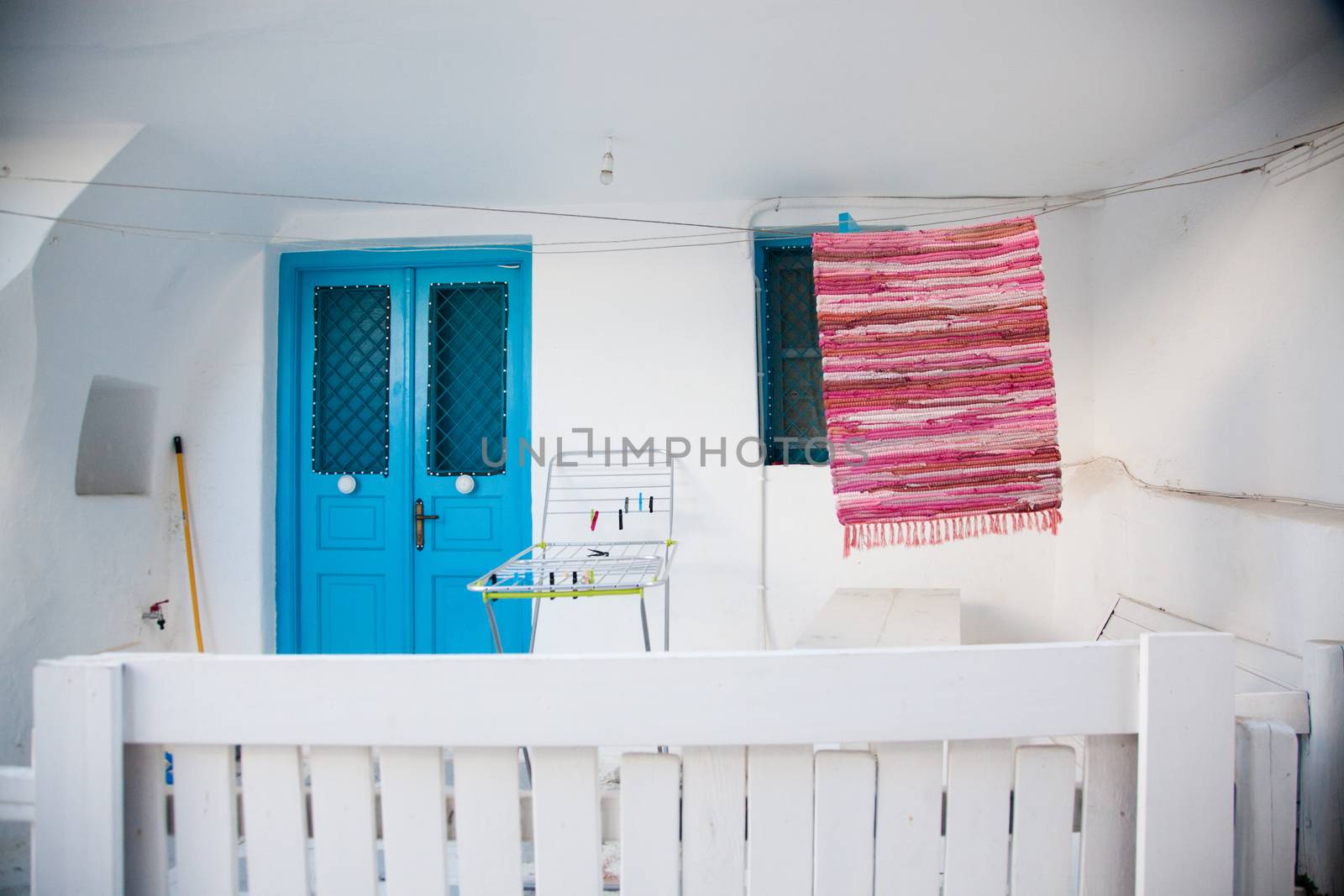 traditional narrow street in Mykonos with blue doors and white walls