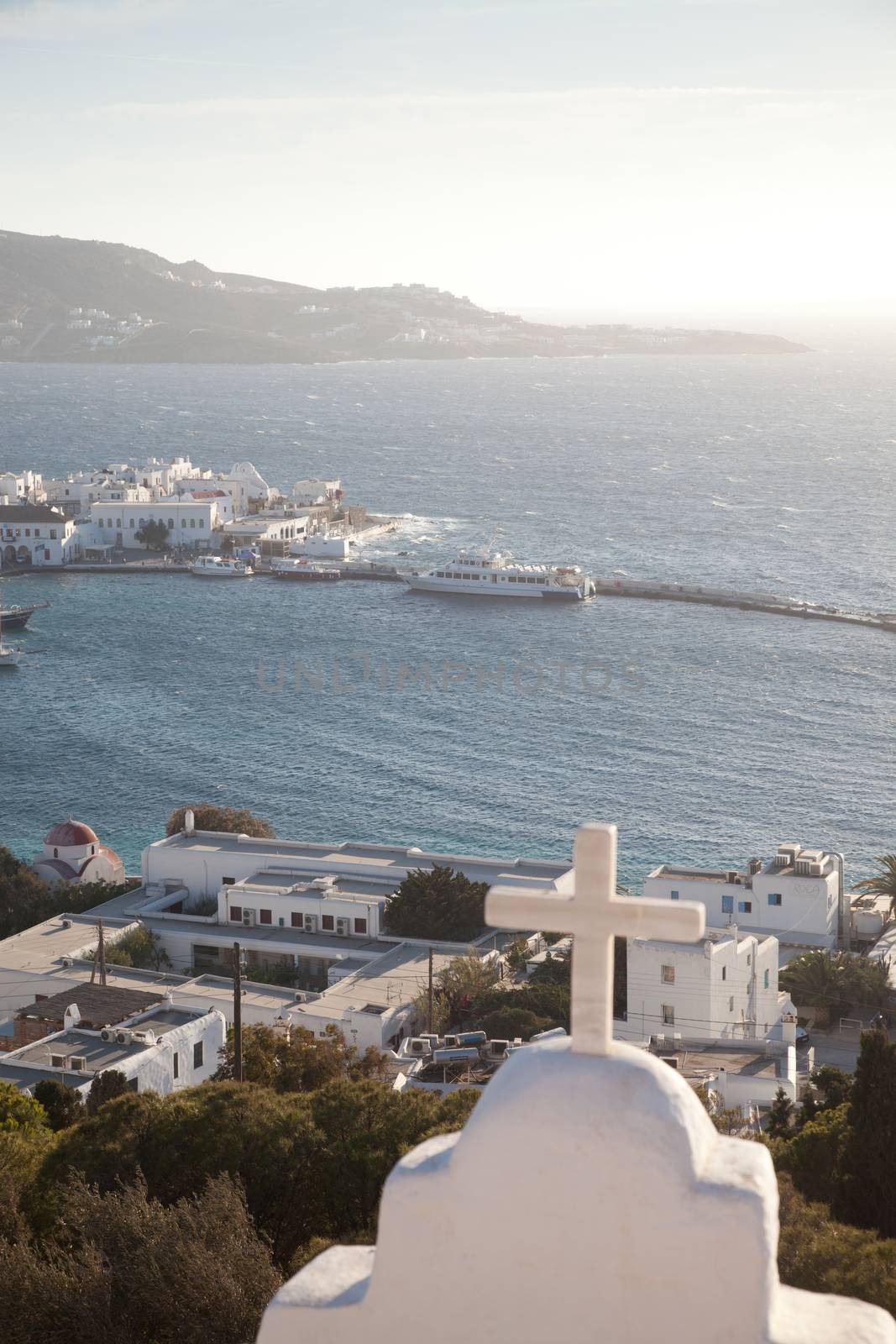 panoramic view of the Mykonos town harbor with famous windmills from the above hills on a sunny summer day, Mykonos, Cyclades, Greece 
