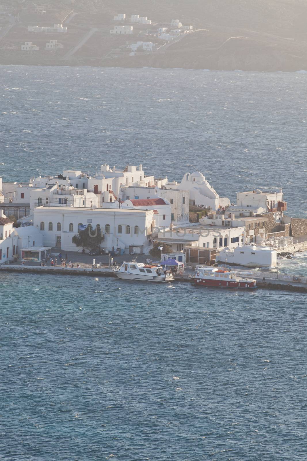 panoramic view of the Mykonos town harbor with famous windmills from the above hills on a sunny summer day, Mykonos, Cyclades, Greece 