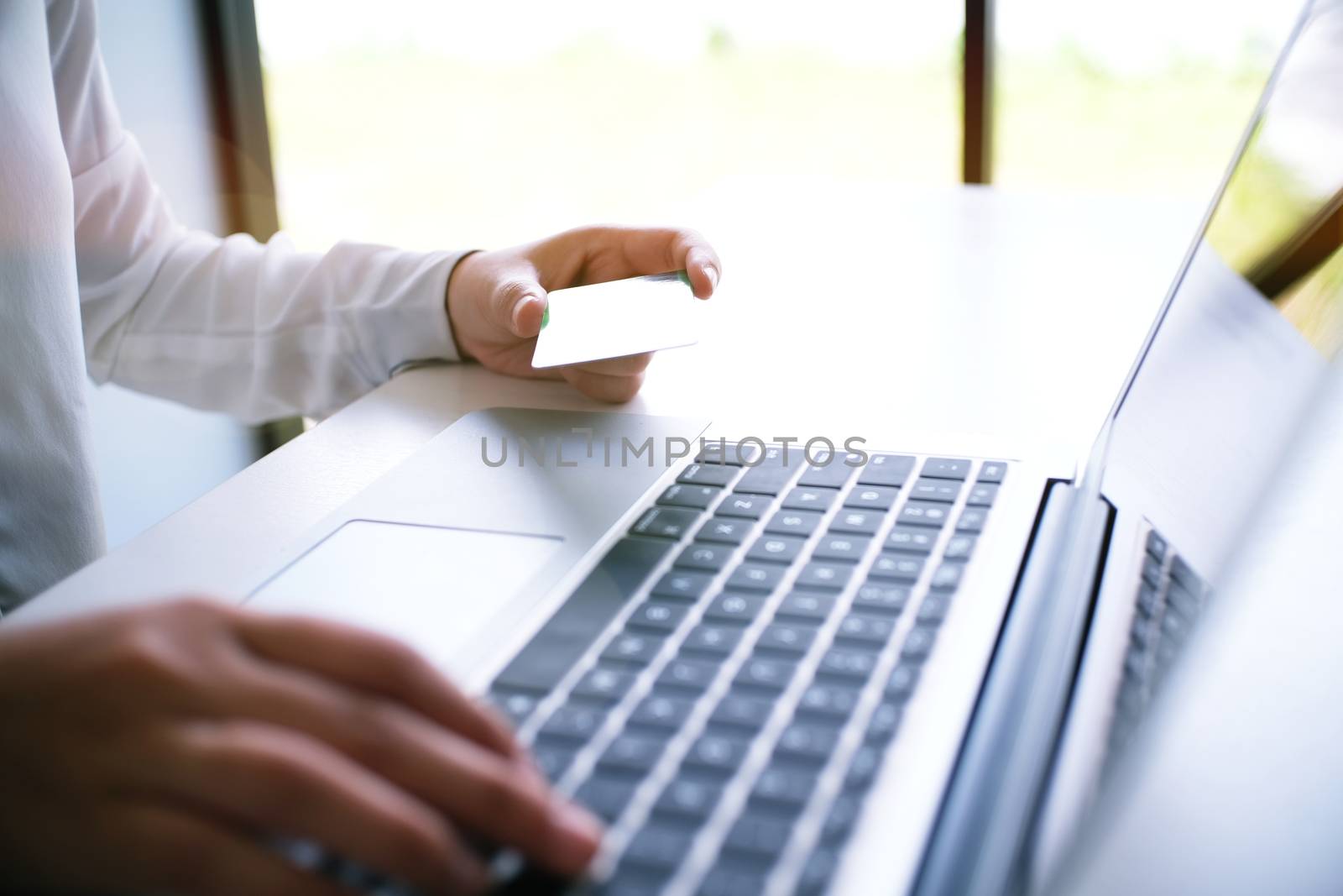Business Woman Hands holding plastic credit card and using lapto by peandben
