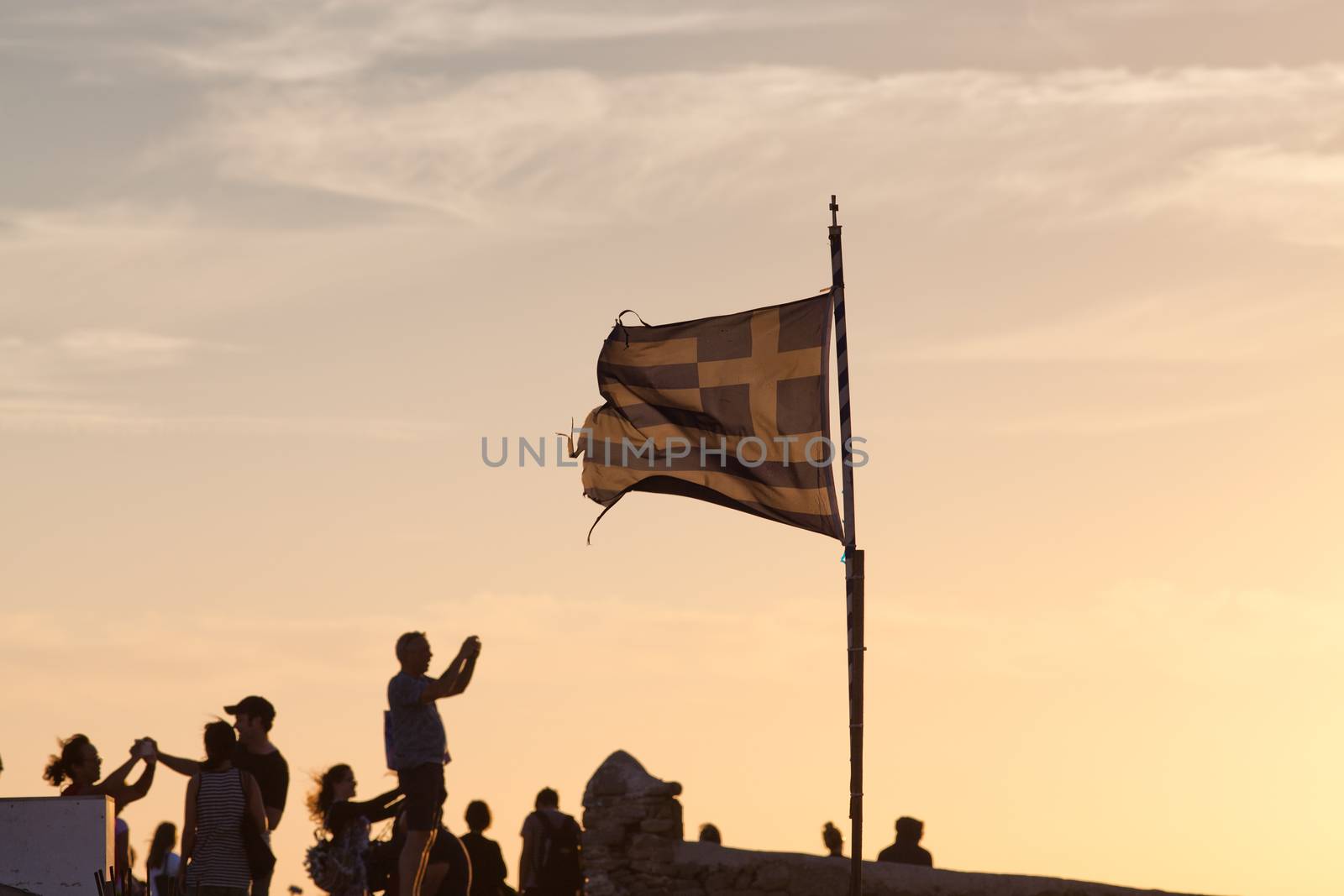 silhouettes of people taking pictures with smartphones and Greek flag