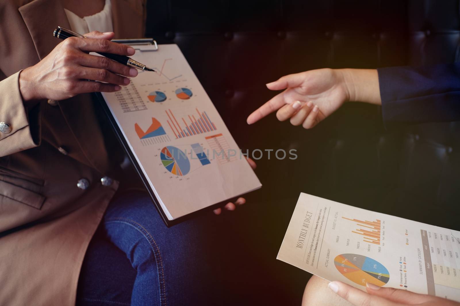 Businesswoman in suit making presentation explaining charts. and discussing a new business project with the members