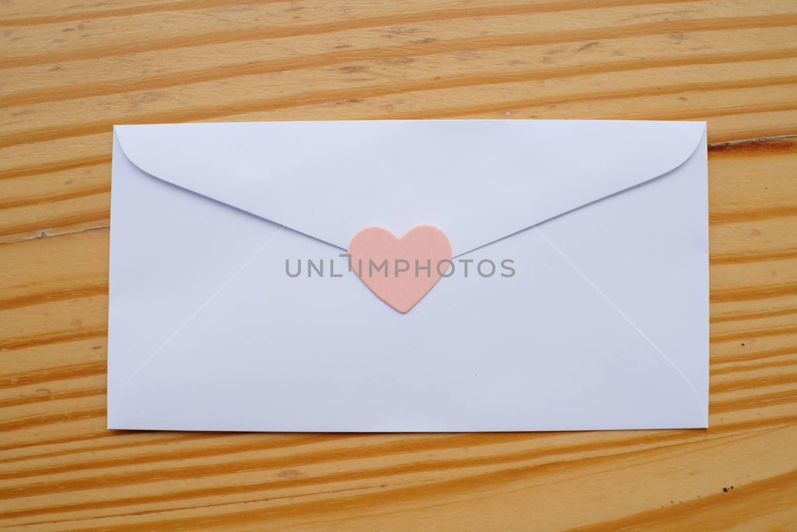 Valentine's day love letter envelope with hearts on wooden background. copy space