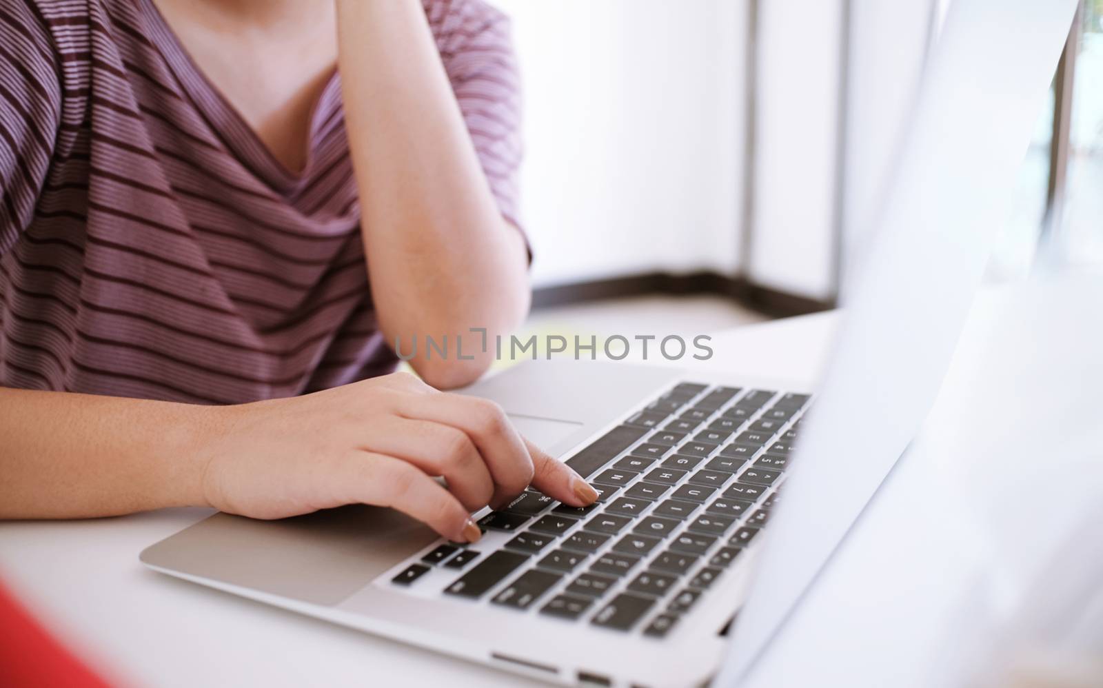 The Casual business woman works online on laptop which hand on keyboard in her house Isolated screen