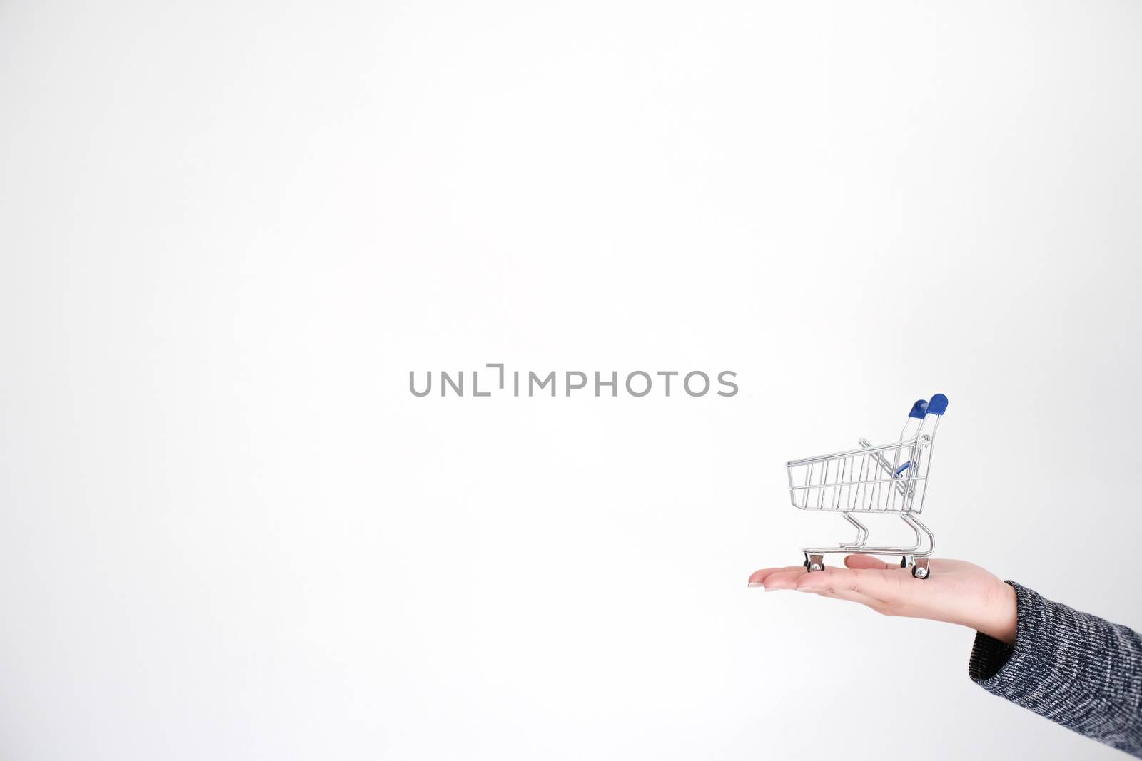 Woman hand forefinger pushing small shopping cart with Internet online shopping concept