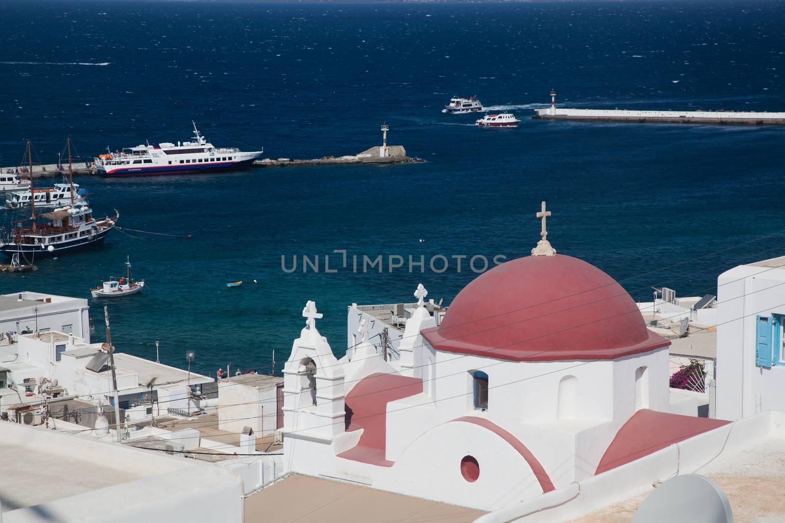 panoramic view of the Mykonos town harbor with famous windmills from the above hills on a sunny summer day, Mykonos, Cyclades, Greece 