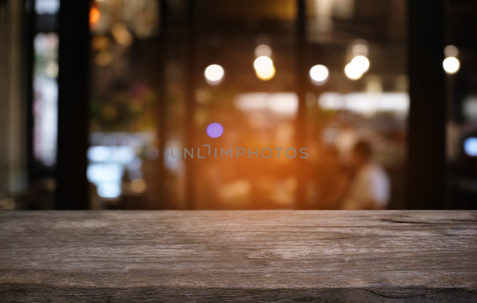 Empty dark wooden table in front of abstract blurred bokeh background of restaurant . can be used for display or montage your products.Mock up for space