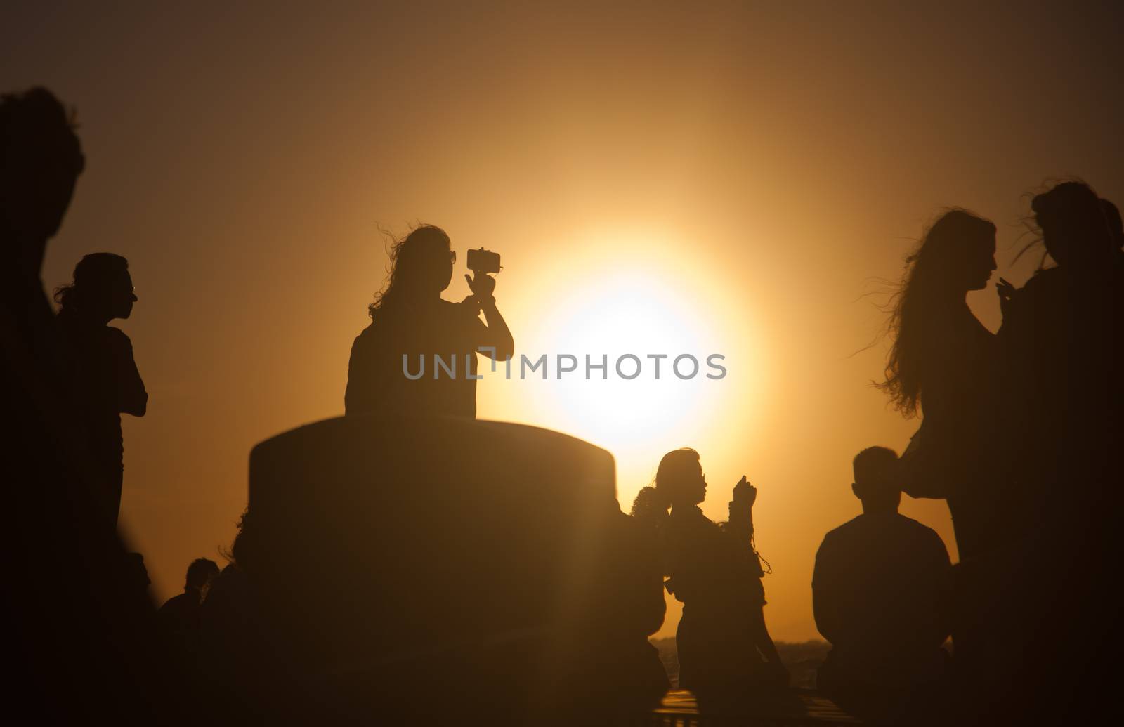 silhouettes of people taking pictures with smartphones by melis