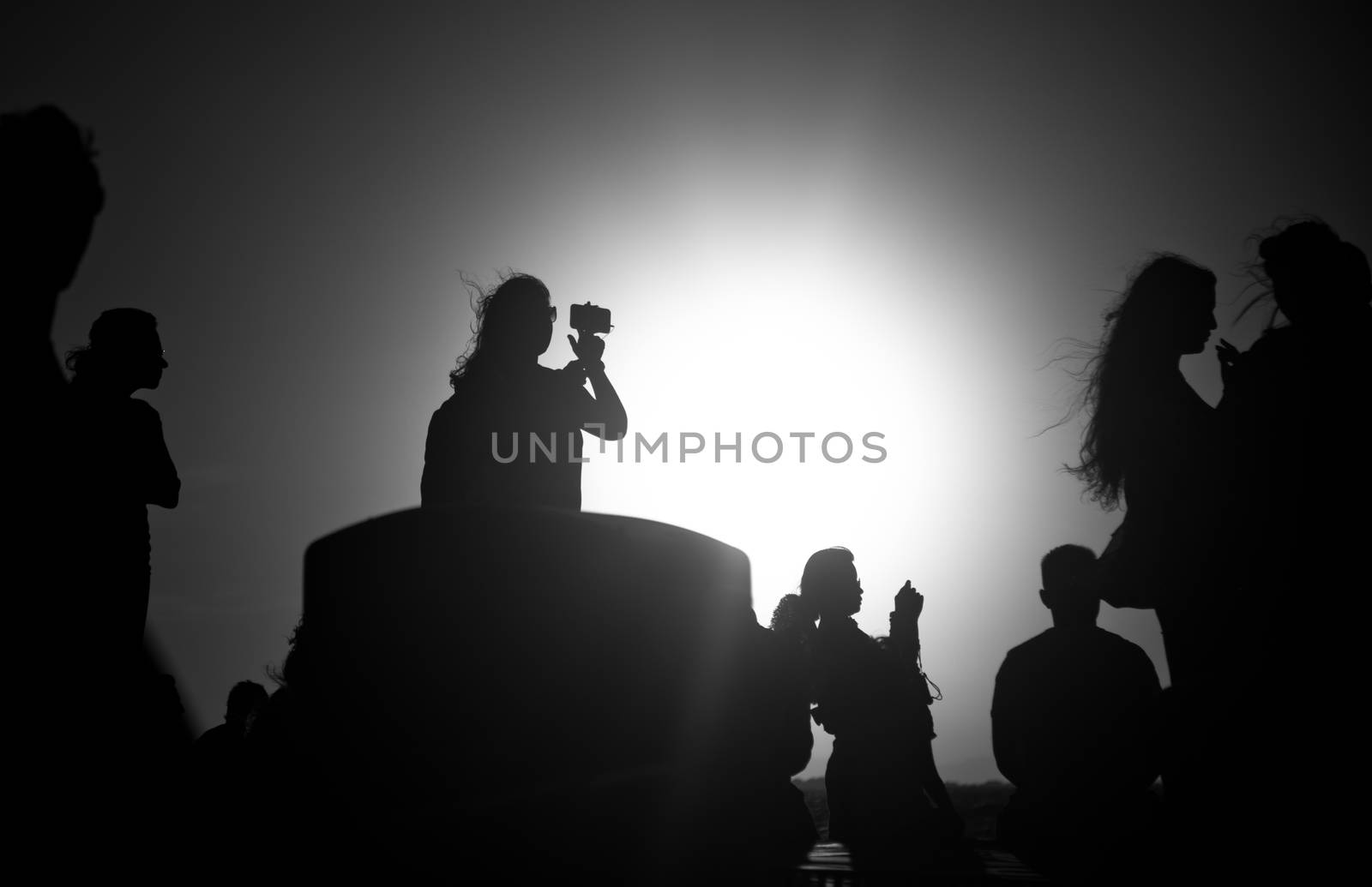 silhouettes of people taking pictures with smartphones