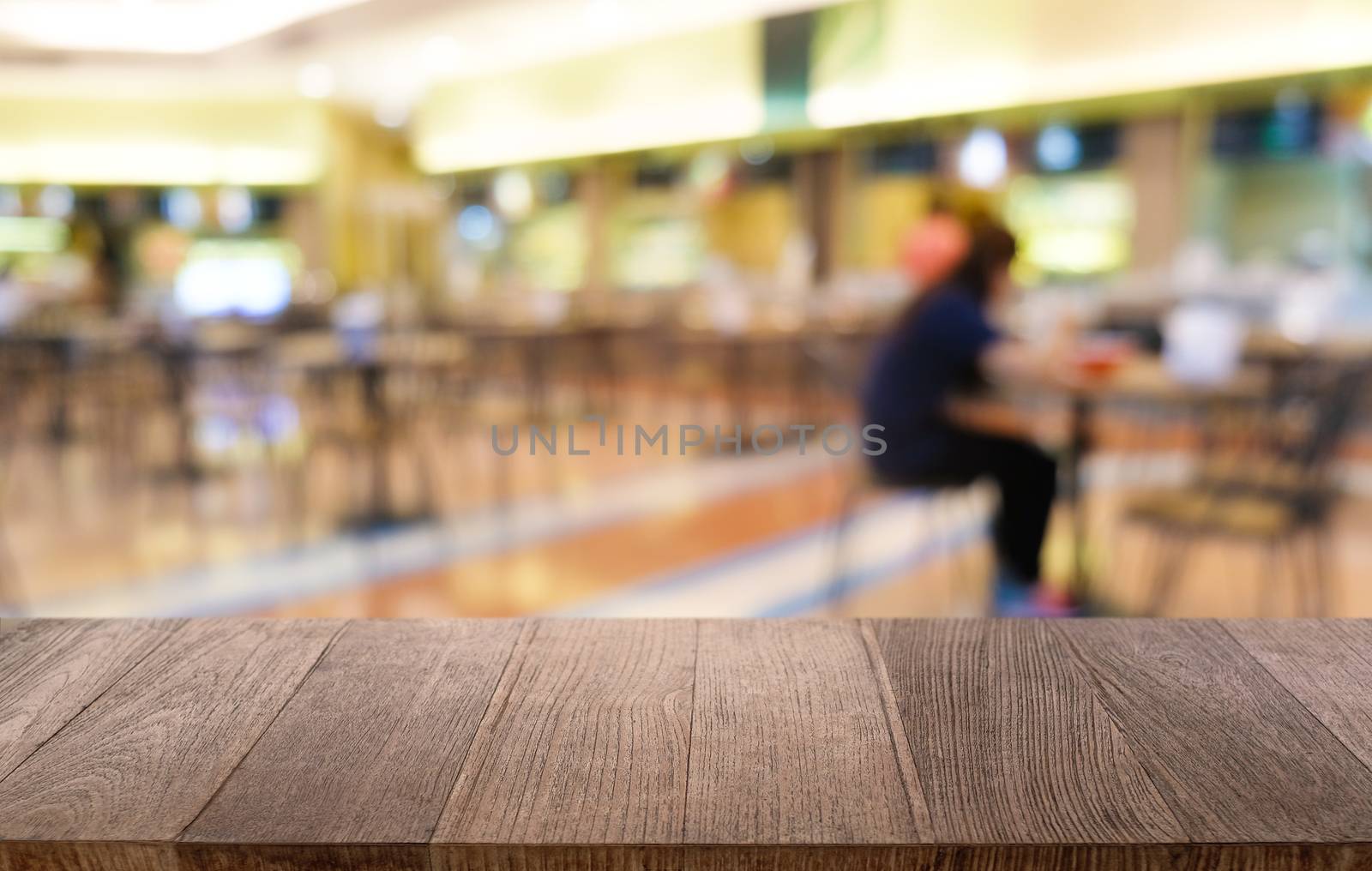 Empty dark wooden table in front of abstract blurred bokeh background of restaurant . can be used for display or montage your products.Mock up for space