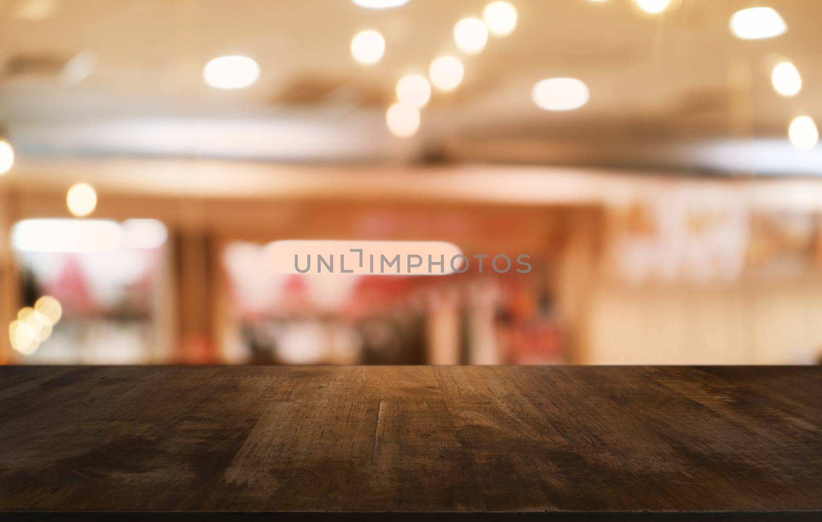 Empty dark wooden table in front of abstract blurred bokeh background of restaurant . can be used for display or montage your products.Mock up for space