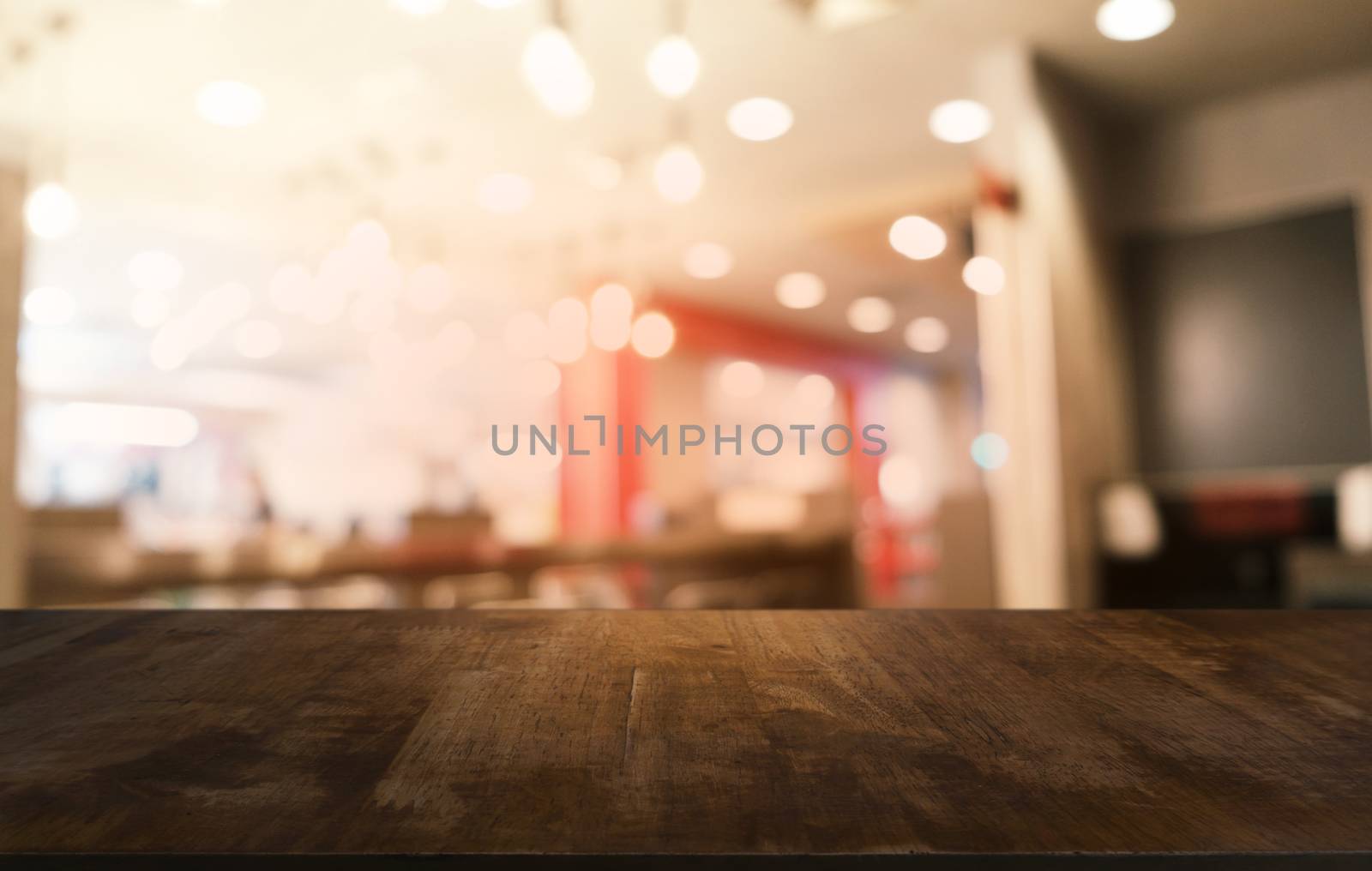 Empty dark wooden table in front of abstract blurred bokeh background of restaurant . can be used for display or montage your products.Mock up for space