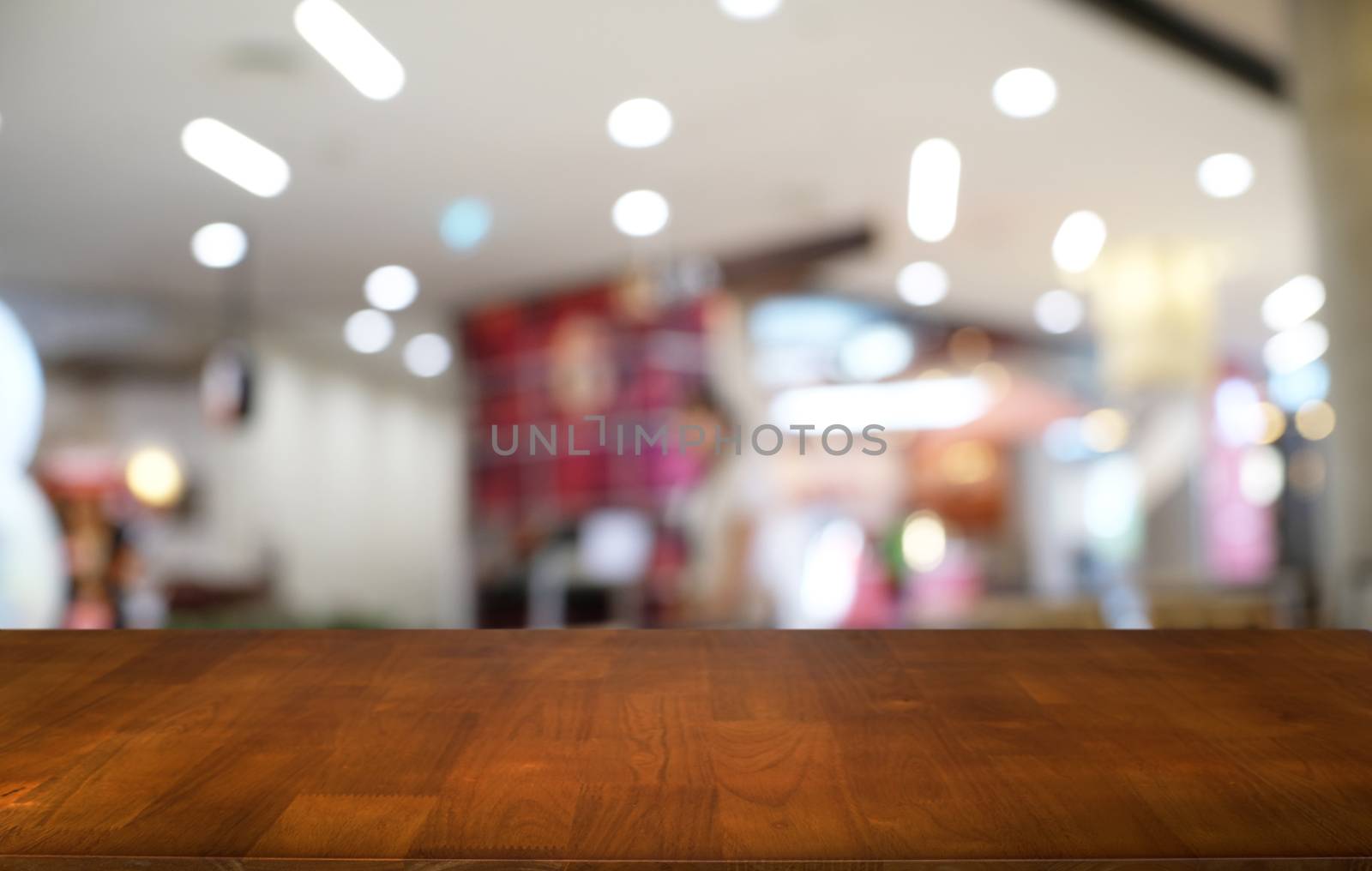 Empty dark wooden table in front of abstract blurred bokeh background of restaurant . can be used for display or montage your products.Mock up for space