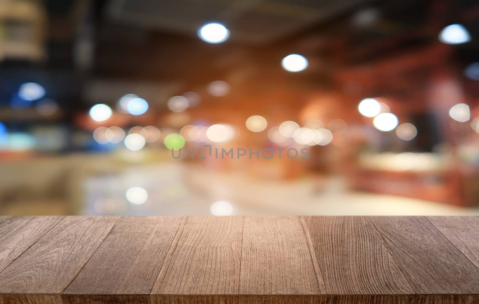 Empty dark wooden table in front of abstract blurred bokeh background of restaurant . can be used for display or montage your products.Mock up for space