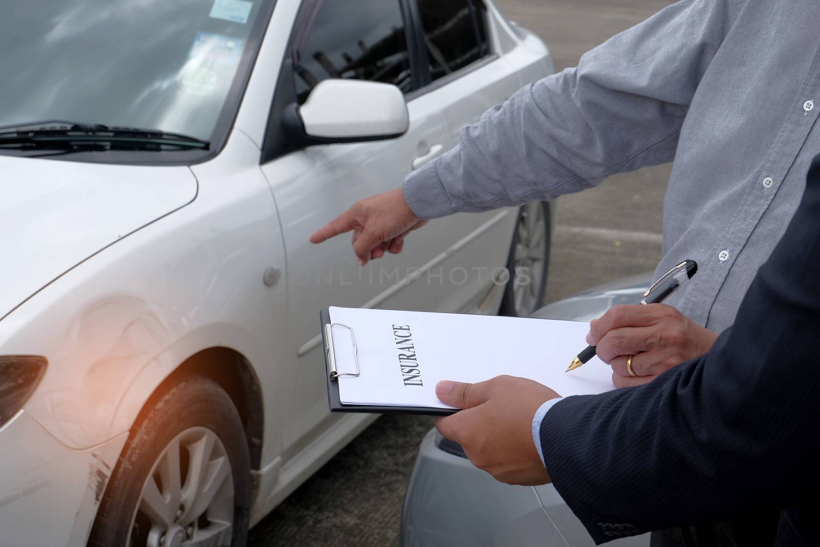 Loss Adjuster Insurance Agent Inspecting Damaged Car. by peandben